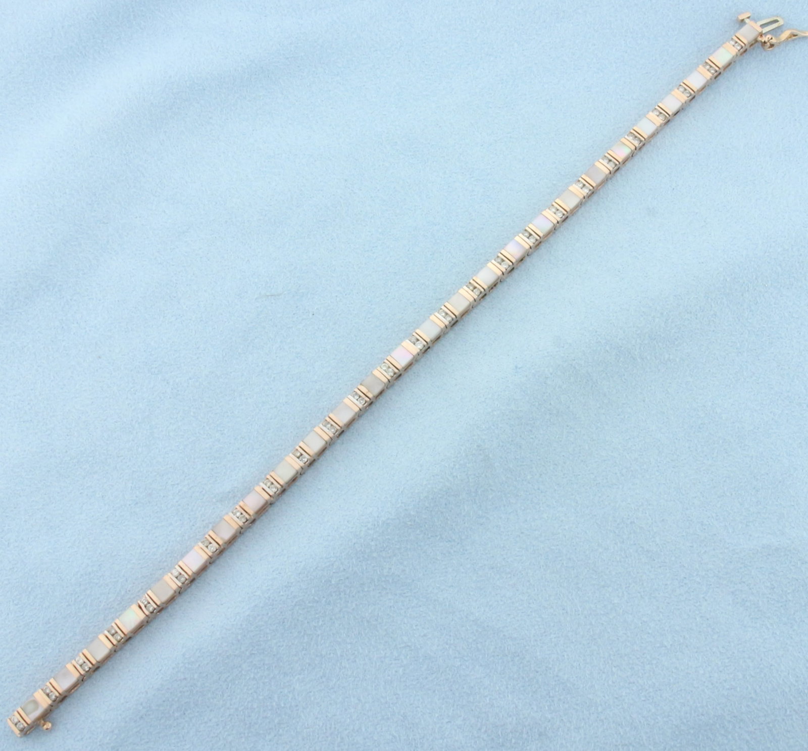 Diamond and Mother of Pearl Inlay Tennis Bracelet in 14k Rose Gold: In 14k rose gold. Contains fifty-two high quality .01ct diamonds, SI2 clarity/H color. Also contains twenty-six high quality 3.2mm by 3mm mother of pearl inlay gemstones with iridescent color. Conceal