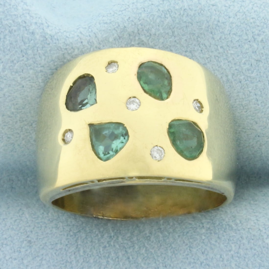 Tsavorite and Diamond Wide Band Ring in 18k Yellow Gold: In 18k yellow gold. Contains four high quality Tsavorite gemstones, approximately 2ct TW, with vibrant color and excellent clarity. Also contains five high quality .02ct diamonds, VS clarity/G color. 
