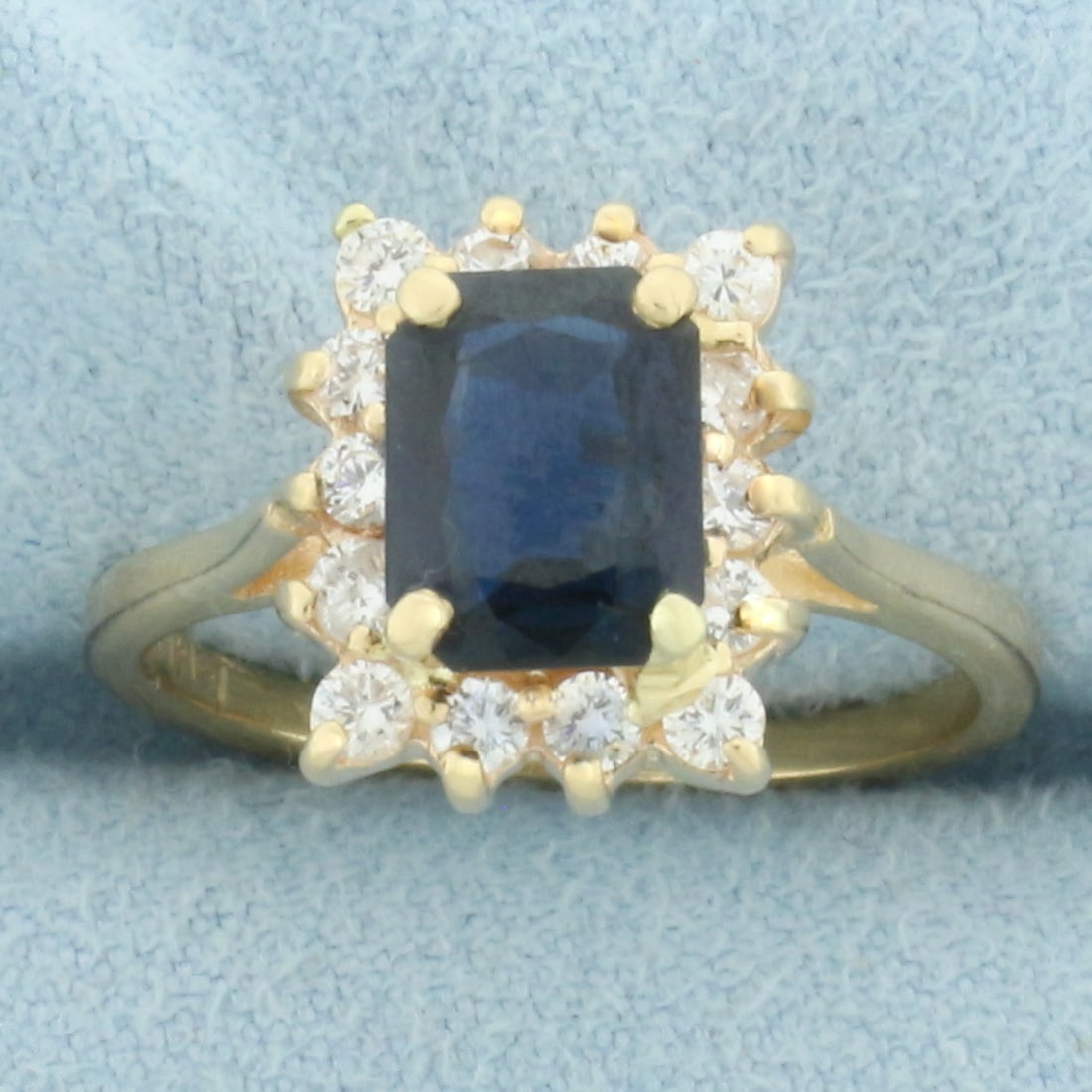 Sapphire and Diamond Halo Ring in 14k Yellow Gold: In 14k Yellow Gold. Contains one natural high AAA quality 8mmx6mm Sapphire gemstone, approximately 1.5ct, with vibrant color and excellent clarity. Also contains fourteen high quality .03ct diamonds, 