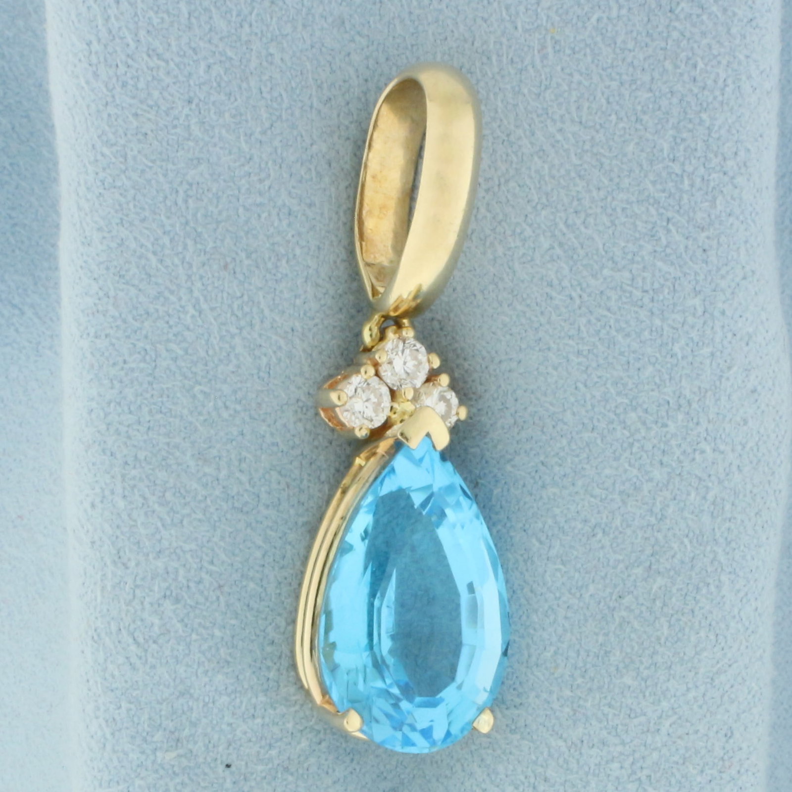 15ct Large Swiss Blue and Diamond Pendant in 14k Yellow Gold: In 14k Yellow Gold. Contains one high quality natural 15ct fancy pear cut Swiss Blue Topaz gemstone with electric blue color an excellent clarity. Also contains three 1/8ct high quality diamonds, VS c