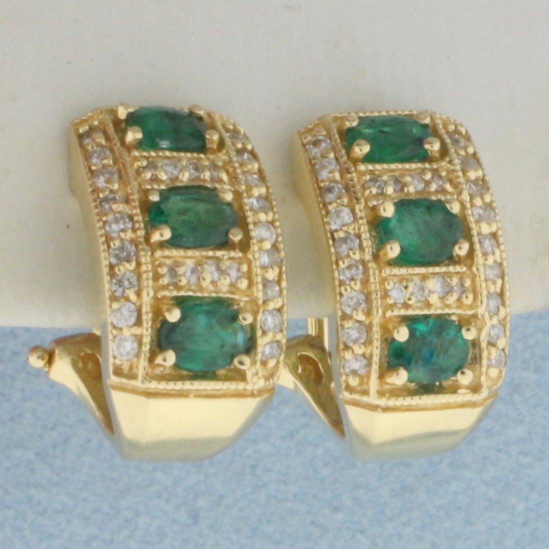 Emerald and Diamond J Hoop Earrings in 14k Yellow Gold: In 14k Yellow Gold. Contains six 4x3mm high quality natural Emerald gemstones with intense color. Also contains fifty-two high quality 1/2pt diamonds. 5/8 inch long. 1/2 inch wide. For Pierced Ears. O