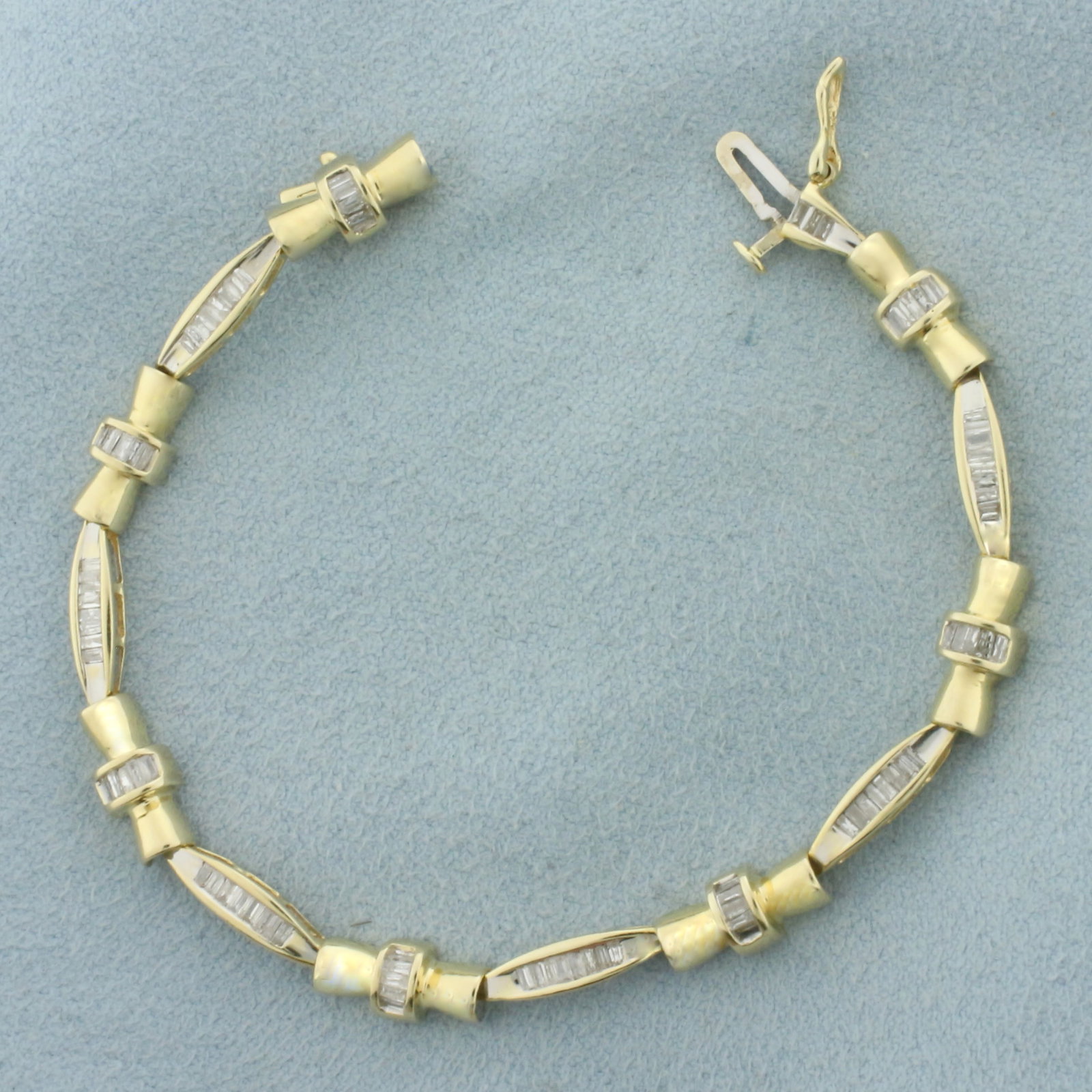 Baguette Diamond Tennis Bracelet in 14k Yellow Gold: In 14k Yellow Gold. Contains one hundred and four high quality baguette diamonds, 1ct TW, SI clarity/G color. 6.5 inches long. 5mm wide. Slide clasp with safety latch. 8.6g.