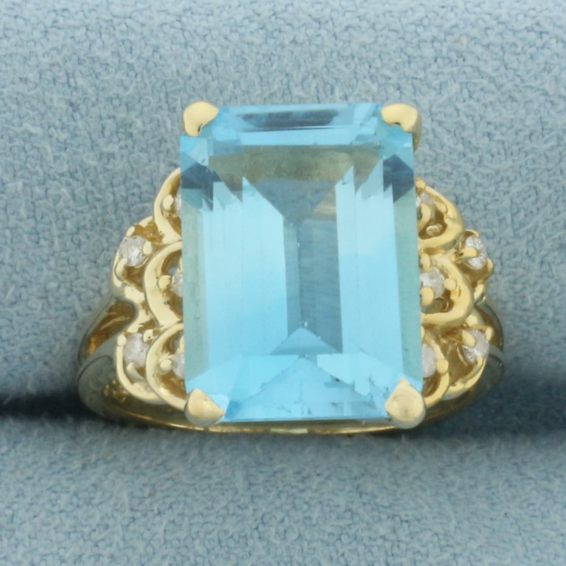 Blue Topaz and Diamond Ring in 14k Yellow Gold: In 14k Yellow Gold. Contains one 14x10mm high quality emerald cut natural Blue Topaz gemstone, approximately 6cts, with vibrant color and excellent clarity. Also contains ten .01ct high quality diamon