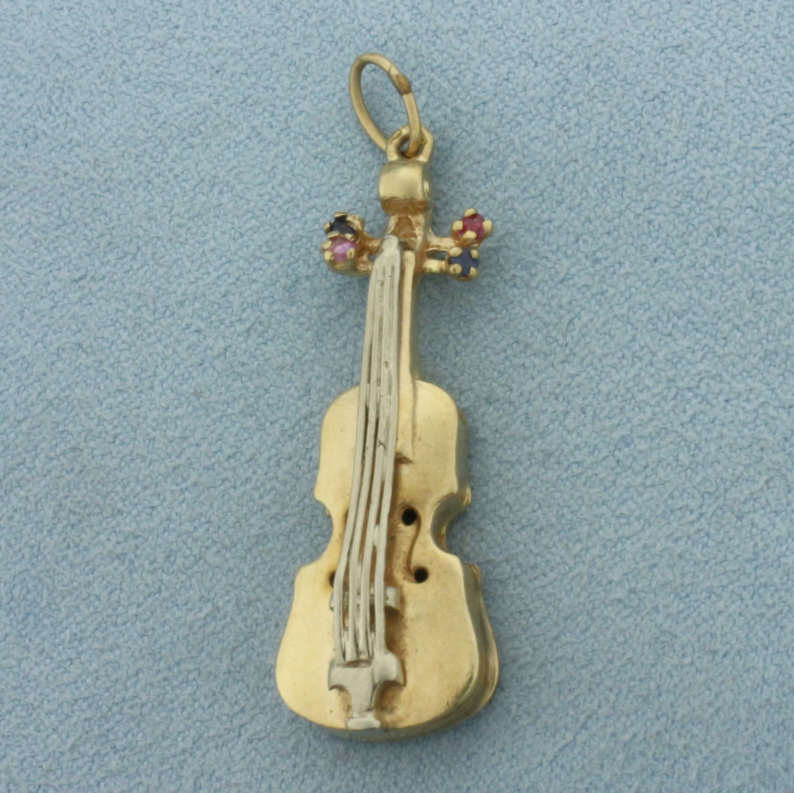 Violin Charm or Pendant in 14k Yellow and White Gold: In 14k Yellow and White Gold. Contains two Ruby and two Sapphire 2mm high quality natural gemstones with vibrant color and excellent clarity. 1 3/4 inch long (including bale). 1/2 inch wide. 6.2g.