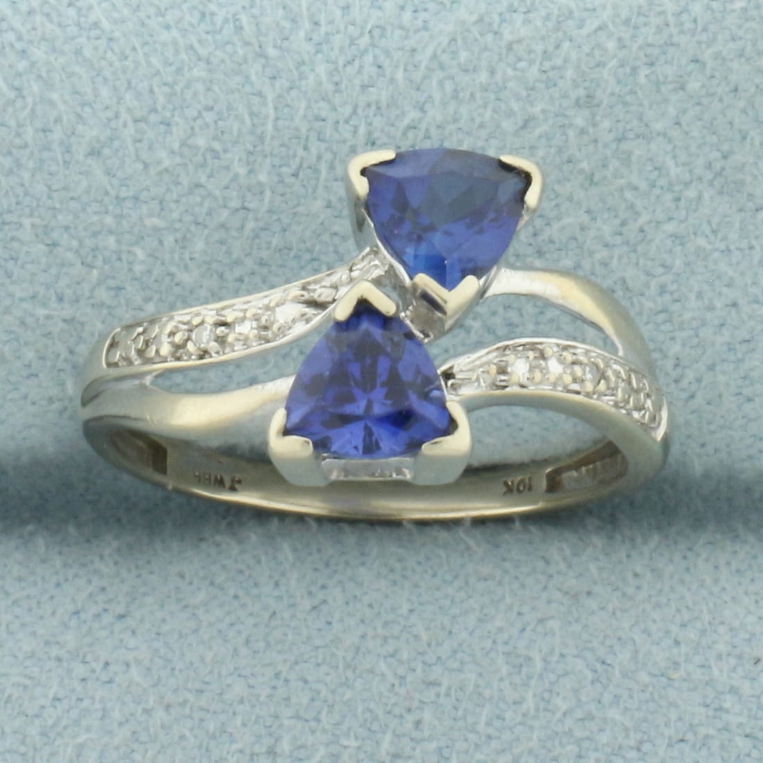Sapphire and Diamond Bypass Ring in 10k White Gold: In 10k White Gold. Contains two high quality 6mm lab created Sapphire gemstones with AAA quality color and clarity. Also contains two high quality 1/2pt diamonds. Size: 6.5. 1.8g.
