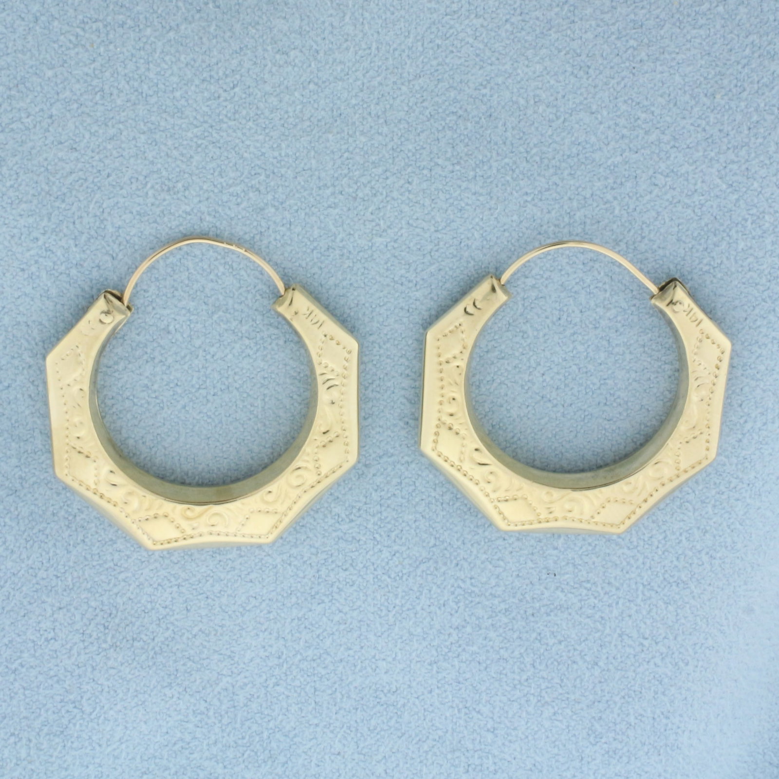 Embossed Hoop Earrings in 14k Yellow Gold: In 14k yellow gold. 1 1/8 inch long by 1 inch wide. Hook closure. 3.6g