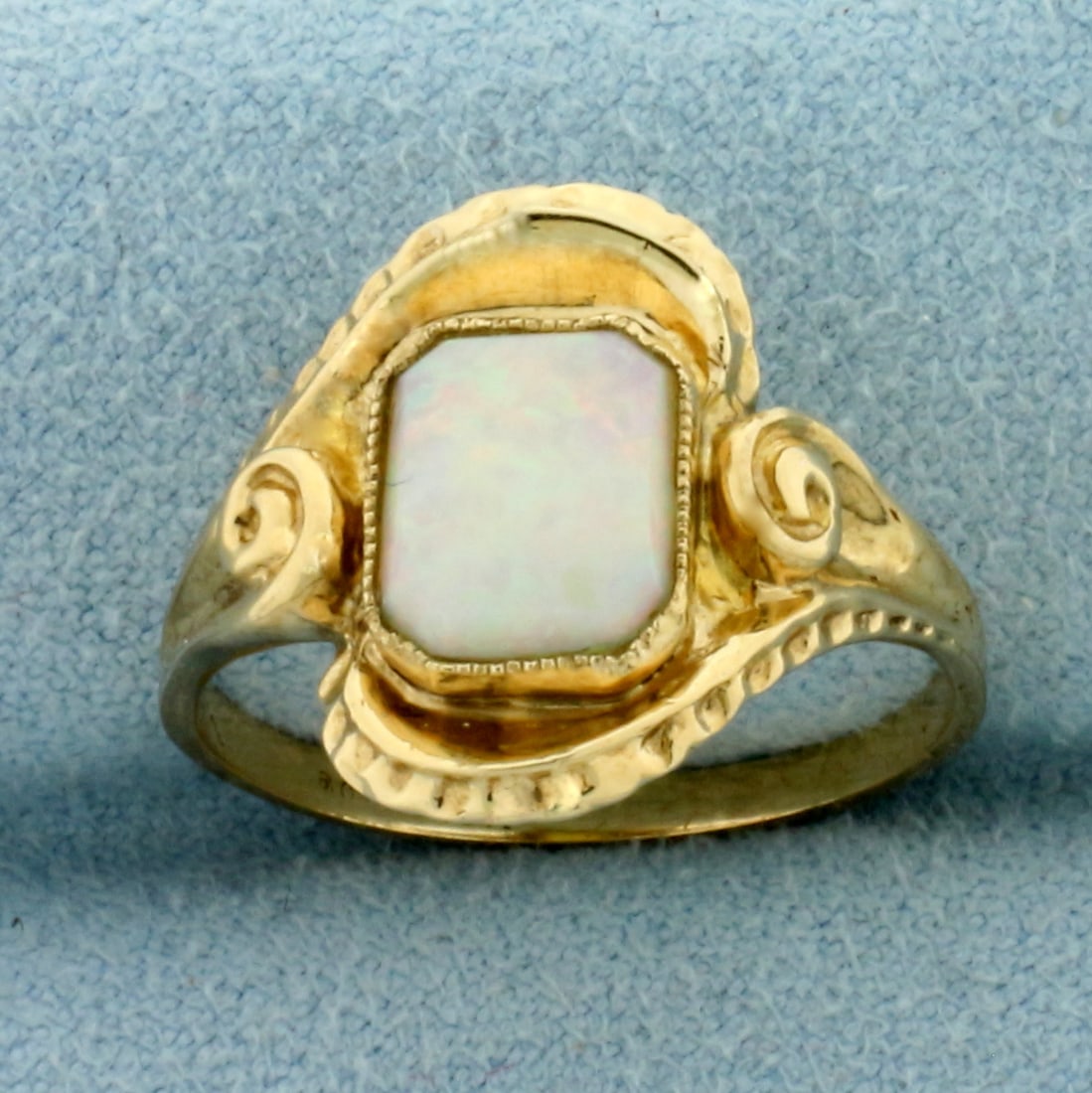 Vintage Opal Solitaire Ring in 10k Yellow Gold: In 10k Yellow Gold. Contains one high quality natural 8mmx7mm Opal with flashes of green, blue, yellow, orange, and red. 15.2mm wide at center. Size 7.25. 3.5g.