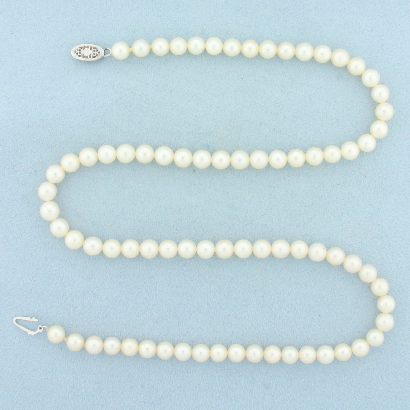 18 Inch Cultured Akoya Pearl Strand Necklace in 14k White Gold: 14k White Gold clasp. Contains 5.5 to 5.75mm high quality Cultured Akoya Pearls with high luster. 18 inches long. Decorative locking filigree clasp. 21.0g.