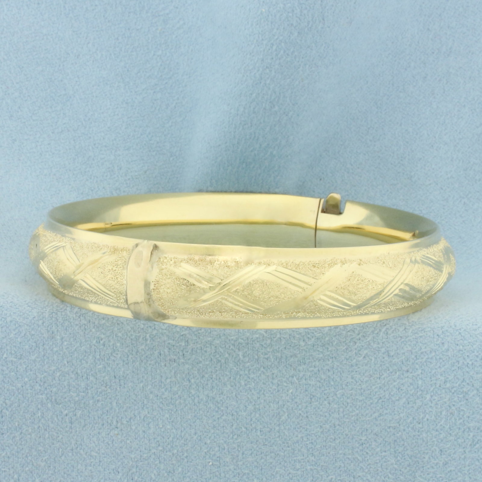 Diamond Cut Sparkle Finish Bangle Bracelet in 14k Yellow Gold: In 14k Yellow Gold. Interior dimensions: 2 3/8 inch by 2 1/8 inch. 10.4mm wide. Hinged closure. 14.3g.