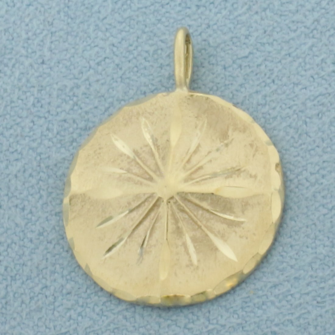 Sand Dollar Pendant in 14k Yellow Gold: In 14k Yellow Gold. 7/8 inch long (including bale). 5/8 inch wide. 2.1g.