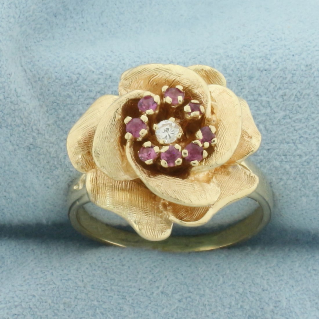 Ruby And Diamonds Rose Flower Ring in 14K Yellow Gold: In 14k yellow gold. 18mm wide at top of ring. Contains 1 high quality .05ct diamond, VS clarity/G color. Also contains eight high quality natural 2mm Ruby gemstones with vibrant color and excellent cl