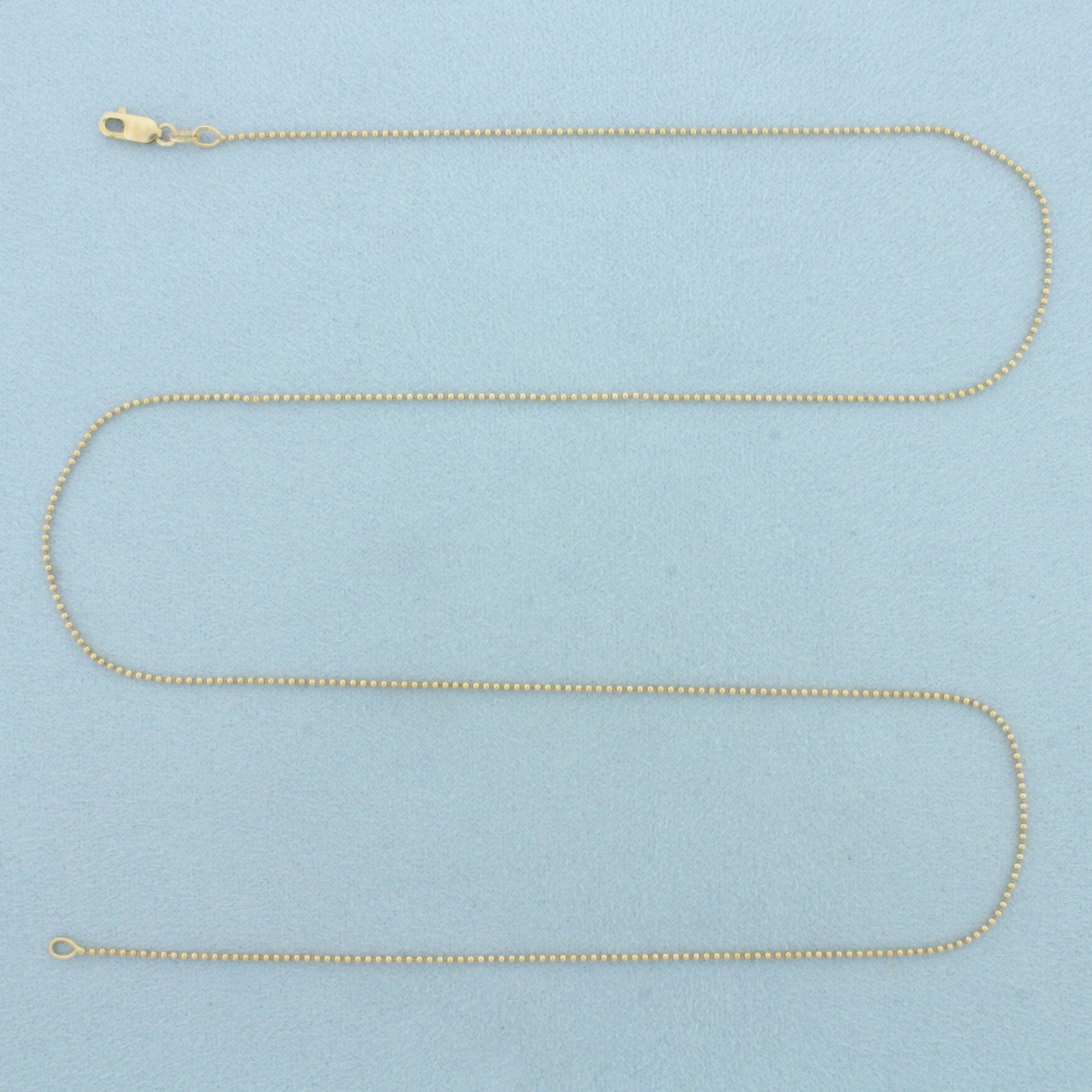 22 Inch Ball Bead Chain Necklace in 14k Yellow Gold: In 14k Yellow Gold. 22 inches long. 1mm wide. Lobster clasp. 2.3g.