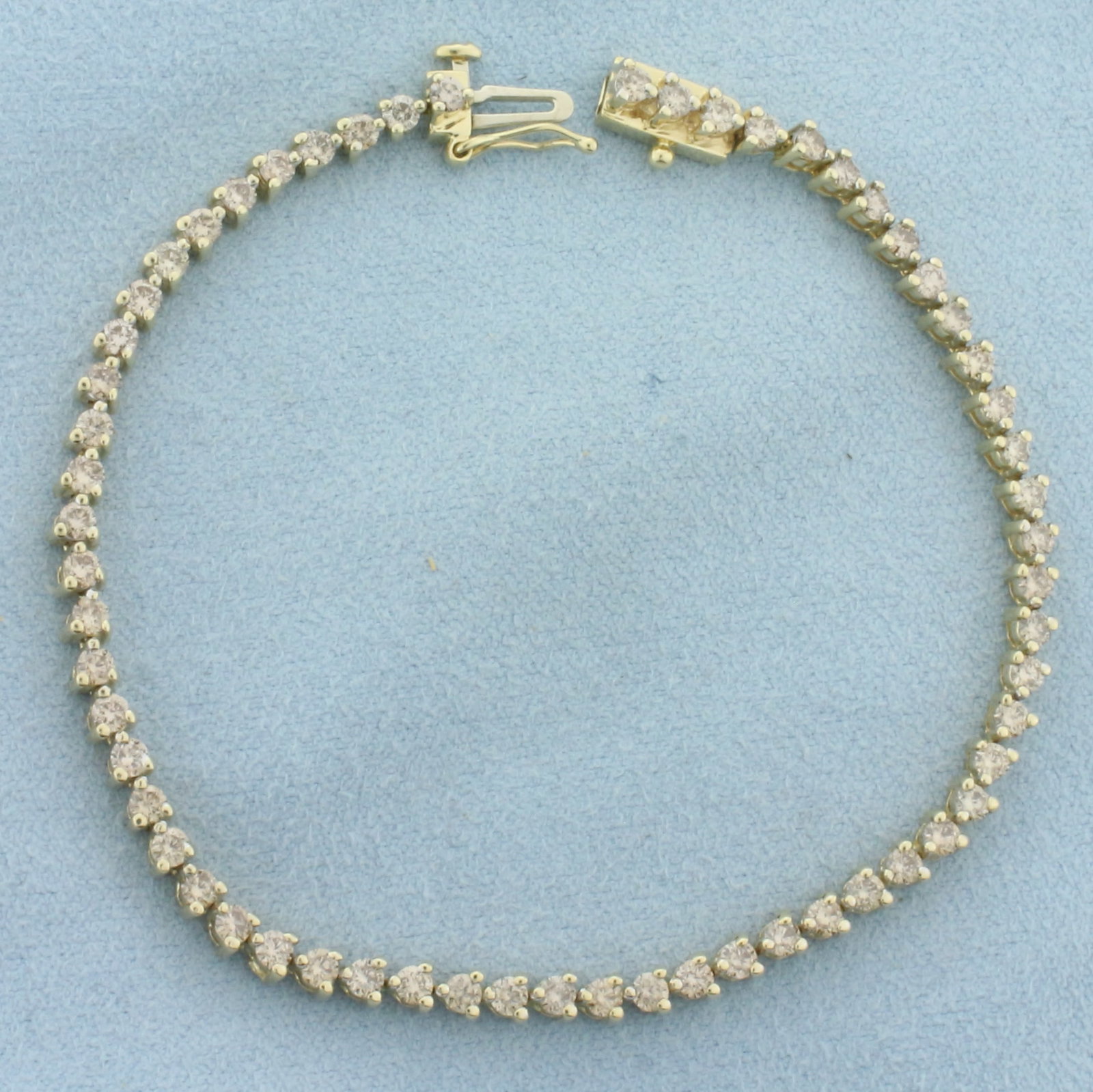 Diamond Tennis Bracelet in 14k Yellow Gold: In 14k Yellow Gold. Contains sixty high quality diamonds, 3ct TW, I color/I clarity. 7 inches long. 3mm wide. Slide clasp with safety latch. 8.7g.