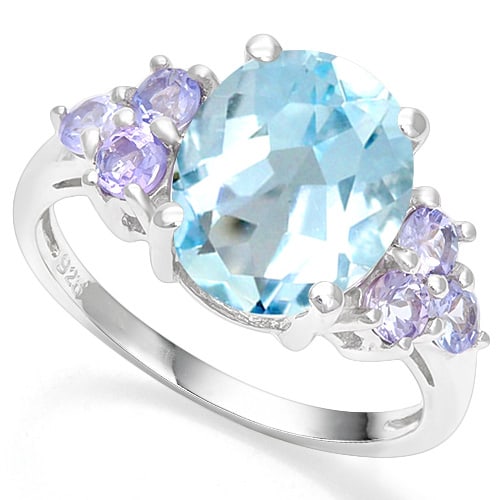 Huge Blue Topaz and Tanzanite Statement Ring in Sterling Silver: In platinum over .925 sterling silver. Contains one 4.3ct blue tanzanite gemstone accented with six tanzanite gems, 0.3ctw. Size 6. 3.5g