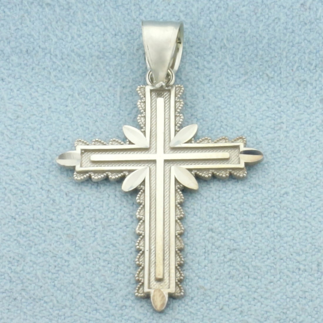 Cross Pendant in 14k White Gold: In 14k White Gold. 1 3/8 inch long (including bale). 7/8 inch wide. 1.6g.