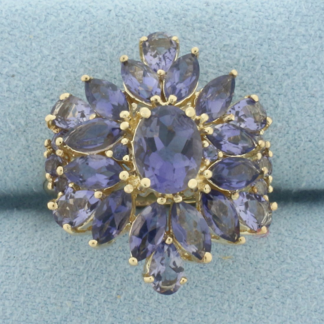 Tanzanite Statement Ring in 10k Yellow Gold: In 10k Yellow Gold. Contains one 8x6mm oval, twelve 6x3mm marquise, six 5x3mm pear and six 2mm round high quality Tanzanite gemstones with bright color and excellent clarity. 24mm wide at top of