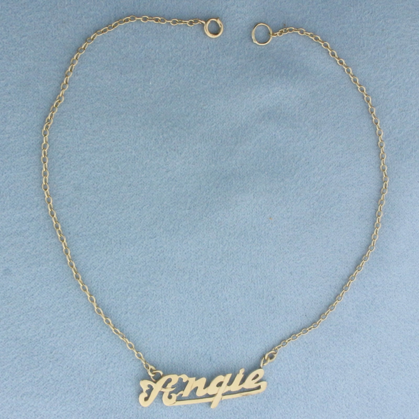 Angie Name Anklet in 14k Yellow Gold: In 14k Yellow Gold. 10 1/4 inches long. 3/8 inch wide at widest spread. Spring clasp. 2.4g.