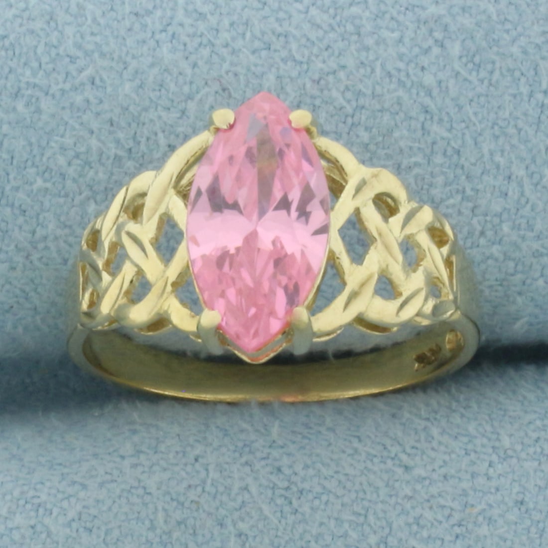 Pink Topaz Woven Design Ring in 10k Yellow Gold: In 10k Yellow Gold. Contains one 12x6mm high quality marquise cut Pink Topaz gemstone, approximately 2cts, with bright color and excellent clarity. Size 6.25. 2.4g.