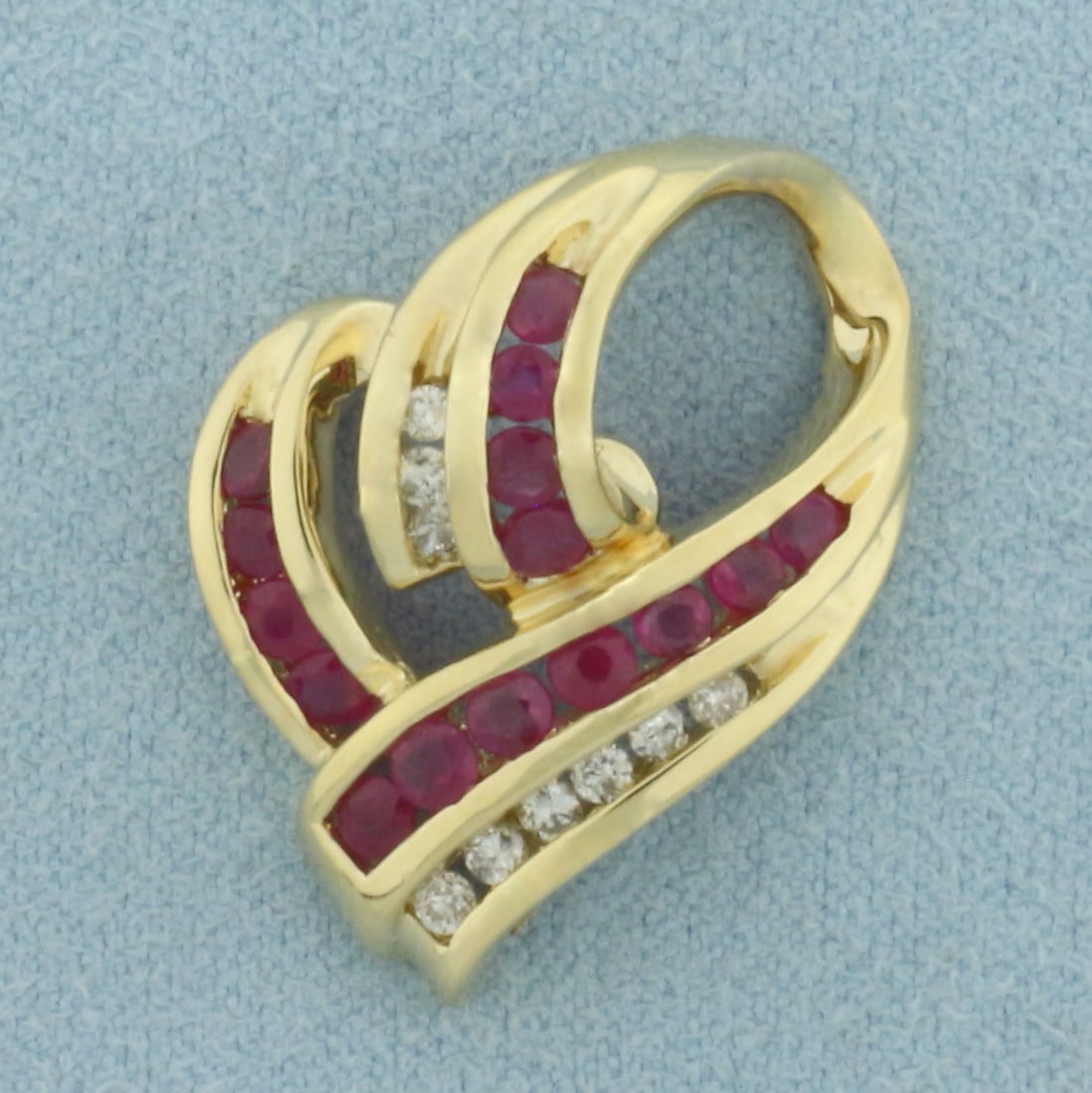 Ruby and Diamond Heart Pendant or Slide in 14k Yellow Gold: In 14k Yellow Gold. Contains fifteen 2-3mm high quality natural Ruby gemstones with vibrant color. Also contains nine high quality .01ct diamonds. 1 inches long. 3/4 inch wide. 5.1g.