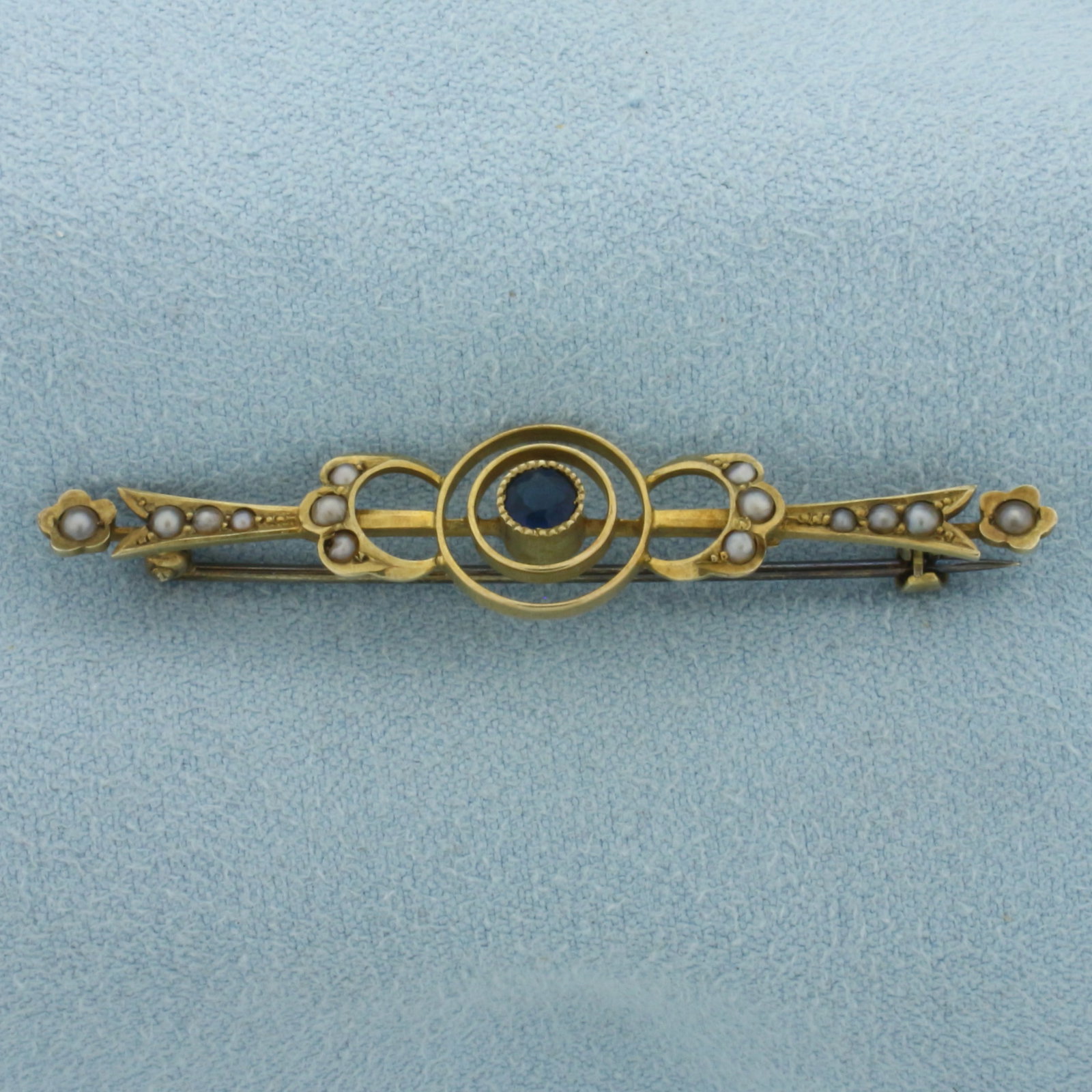 Antique Sapphire and Seed Pearl Brooch Pin in 14k Yellow Gold: In 14k Yellow Gold. Contains one 3.5mm high quality Old European Cut Sapphire gemstone with intense color. Also contains fourteen 1.25-2mm high quality seed pearls. 2 inch wide. 3/8 inch long. 2.8g.