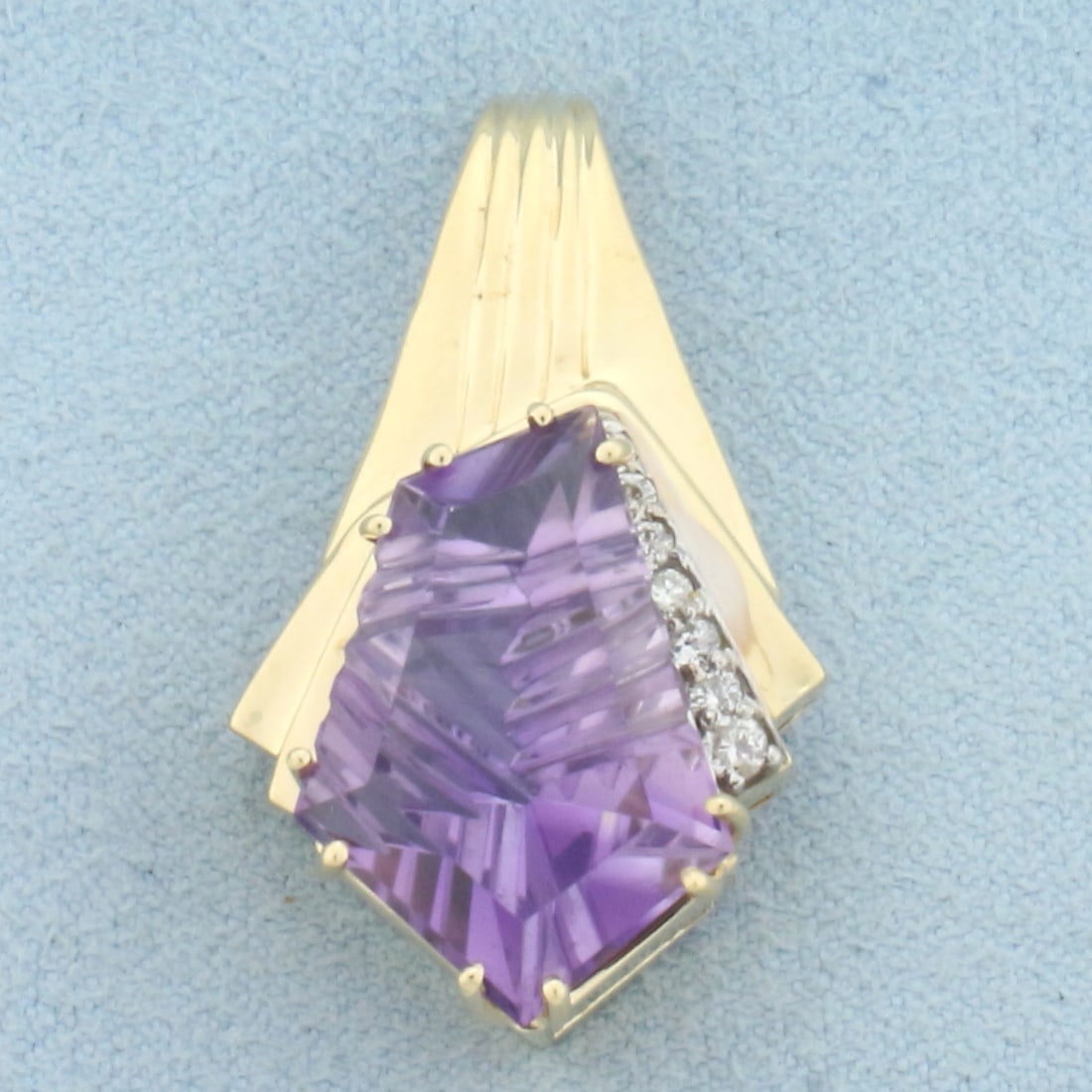 Unique Fancy Cut Amethyst and Diamond Pendant in 14k Yellow Gold: In 14k Yellow Gold. Contains one high quality natural fancy cut 19mmx15mm Amethyst gemstone with rich color and excellent clarity. Also contains seven .02ct high quality diamonds, SI clarity/H color. 