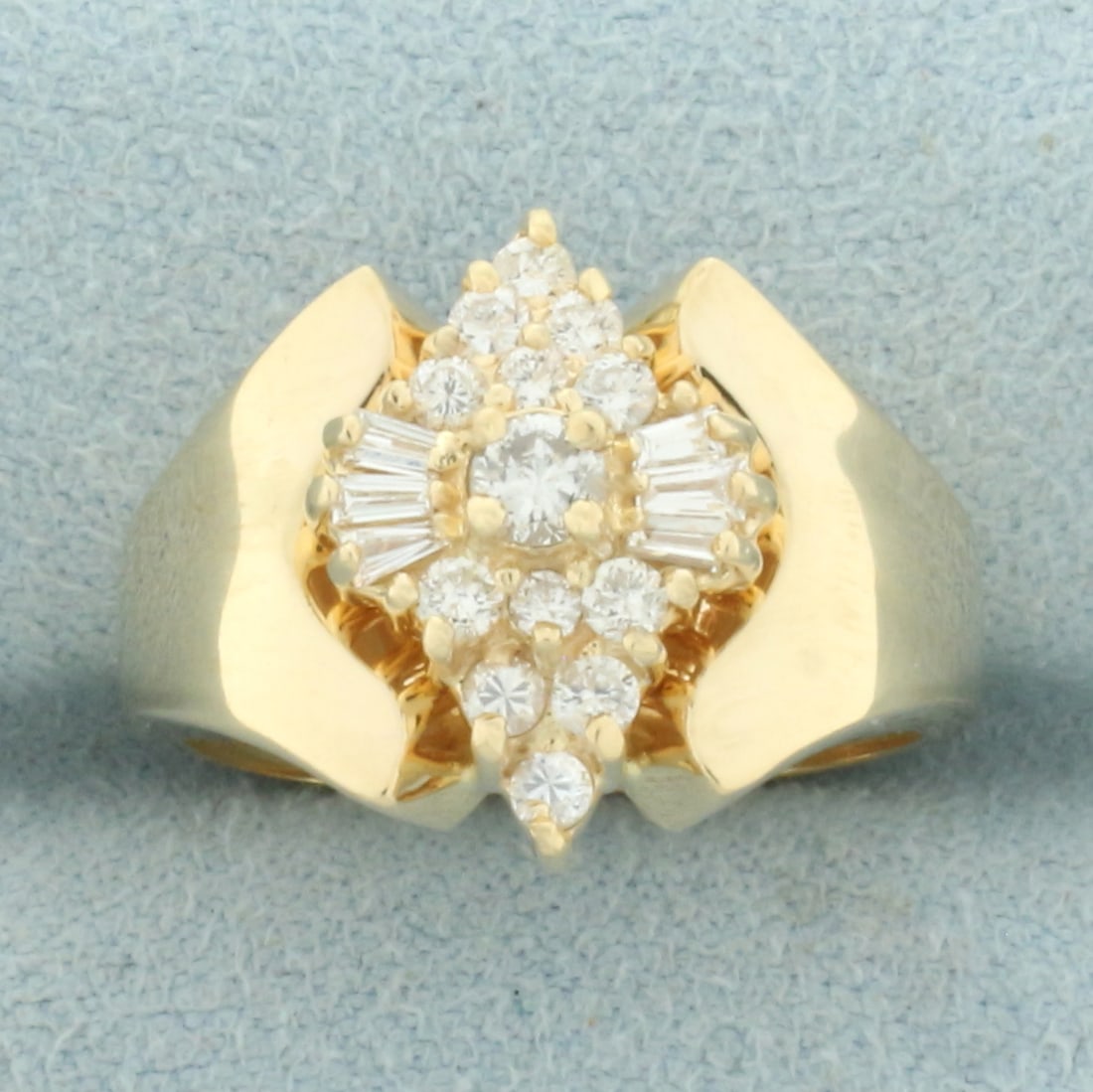 Round and Baguette Diamond Cocktail Ring in 14k Yellow Gold: In 14k yellow gold. Contains one .1ct and twelve .02ct high quality round brilliant diamonds, SI clarity/G color. Also contains six 2.5mm high quality baguette diamonds of similar high quality. 15mm w
