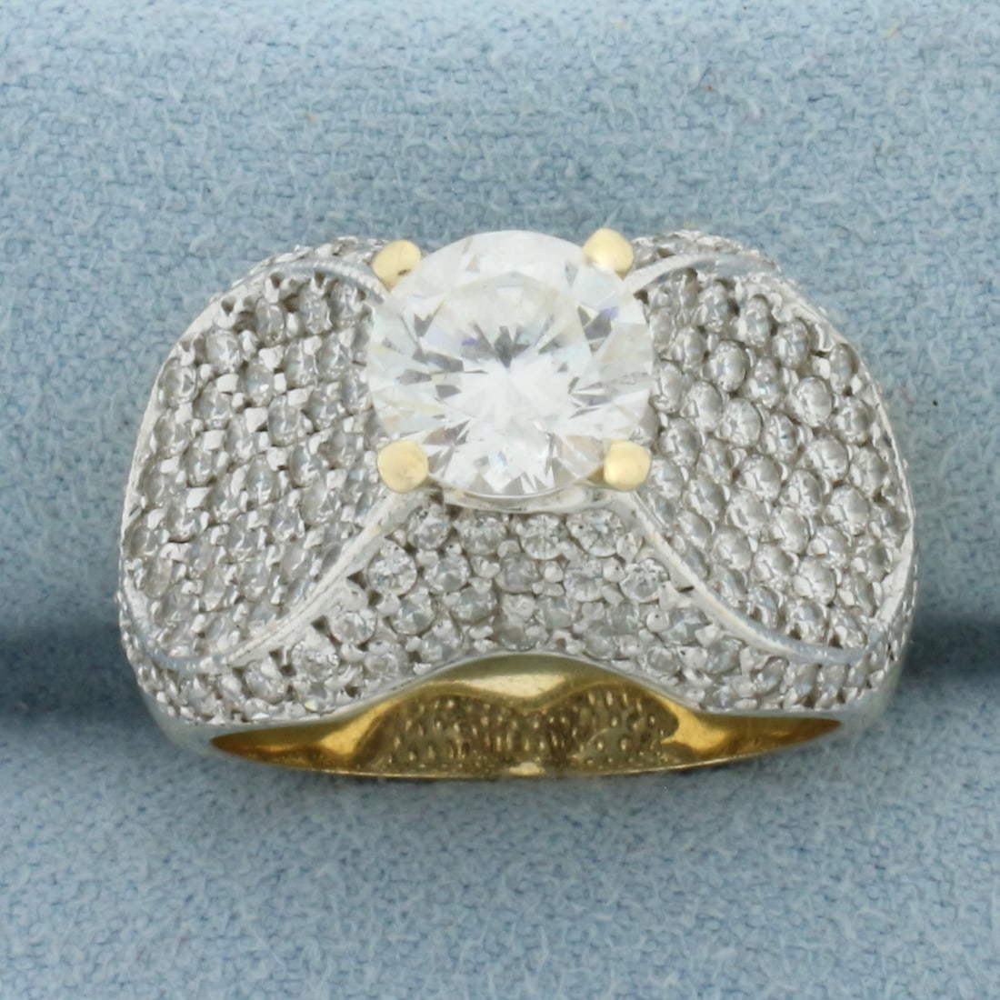 Pave CZ Engagement Ring in 14k Yellow Gold: In 14k Yellow Gold. Contains one high quality 1.5ct CZ gemstone with excellent cut and clarity for added brilliance. Also contains 164 .01ct CZ gemstones of similar high quality. 14mm wide at widest. 