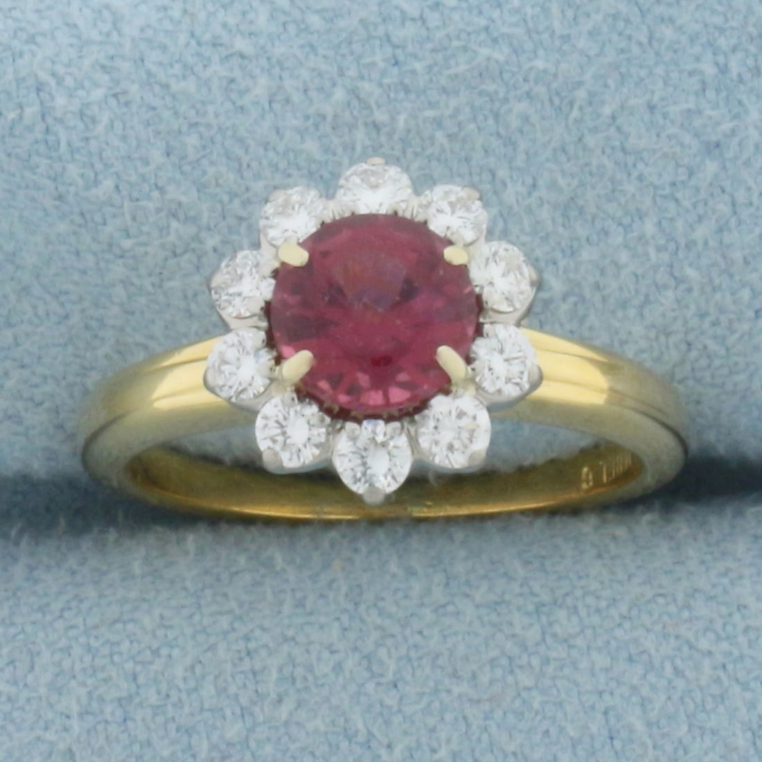 Vintage Rubellite and Diamond Halo Ring in 18k Yellow Gold: In 18k Yellow Gold. Contains one 6mm high quality natural Rubellite gemstone, approximately 3/4ct, with intense color. Minor abrasion on stone, indicative of age. Also contains ten .03ct high quality 