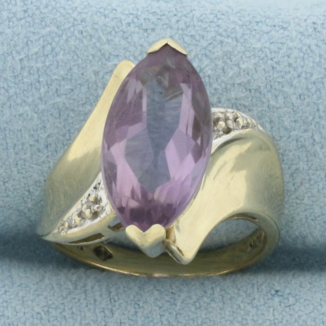 Vintage Marquise Amethyst and Diamond Ring in 10k Yellow Gold: In 10k Yellow Gold. Contains one 16x8mm high quality marquise cut natural Amethyst gemstone, approximately 3cts, with bright color and excellent clarity. Also contains four high quality 1/2pt diamonds