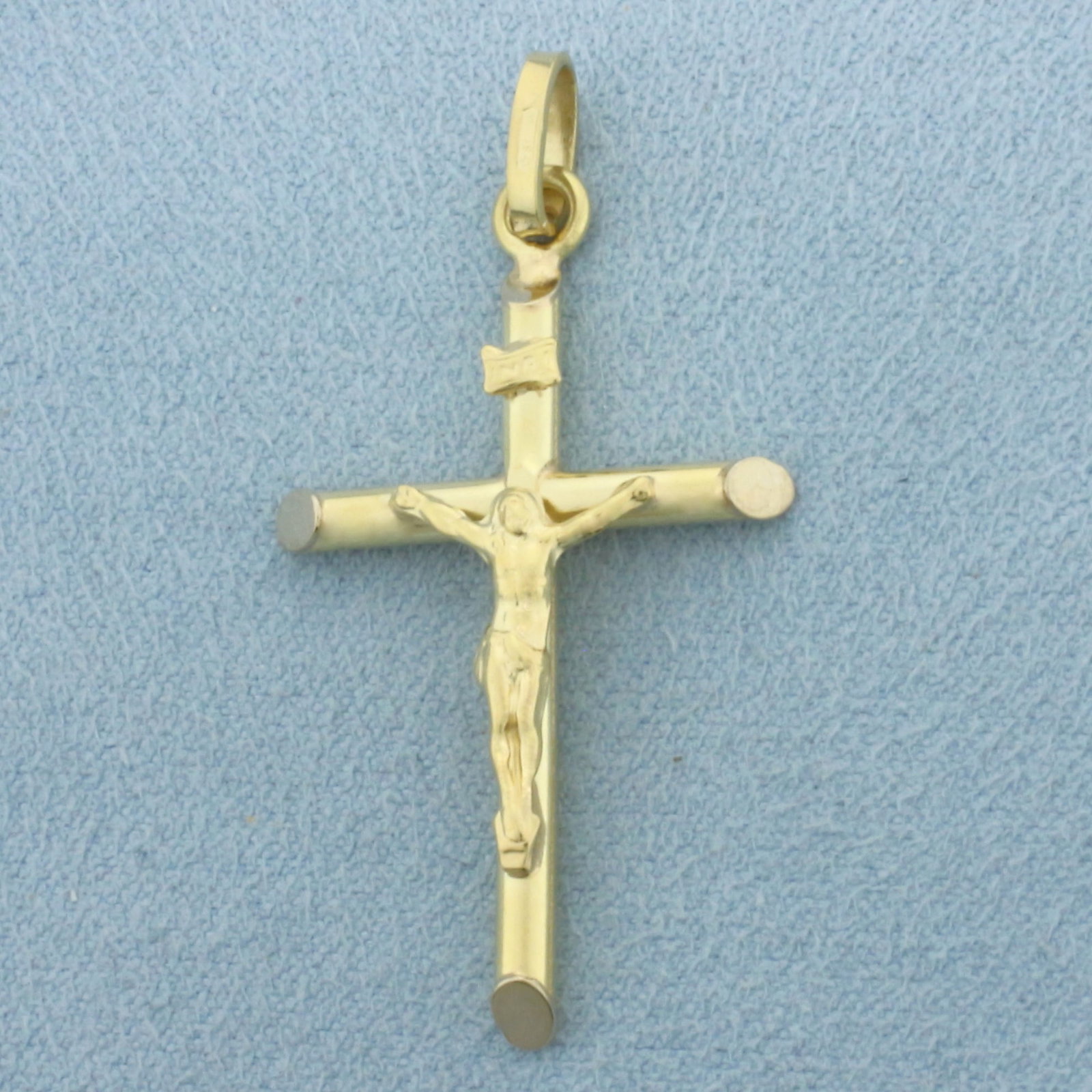 Crucifix Pendant in 18k Yellow Gold: In 18k Yellow Gold. 1 5/8 inch long (including bale). 7/8 inch wide. 2.6g.