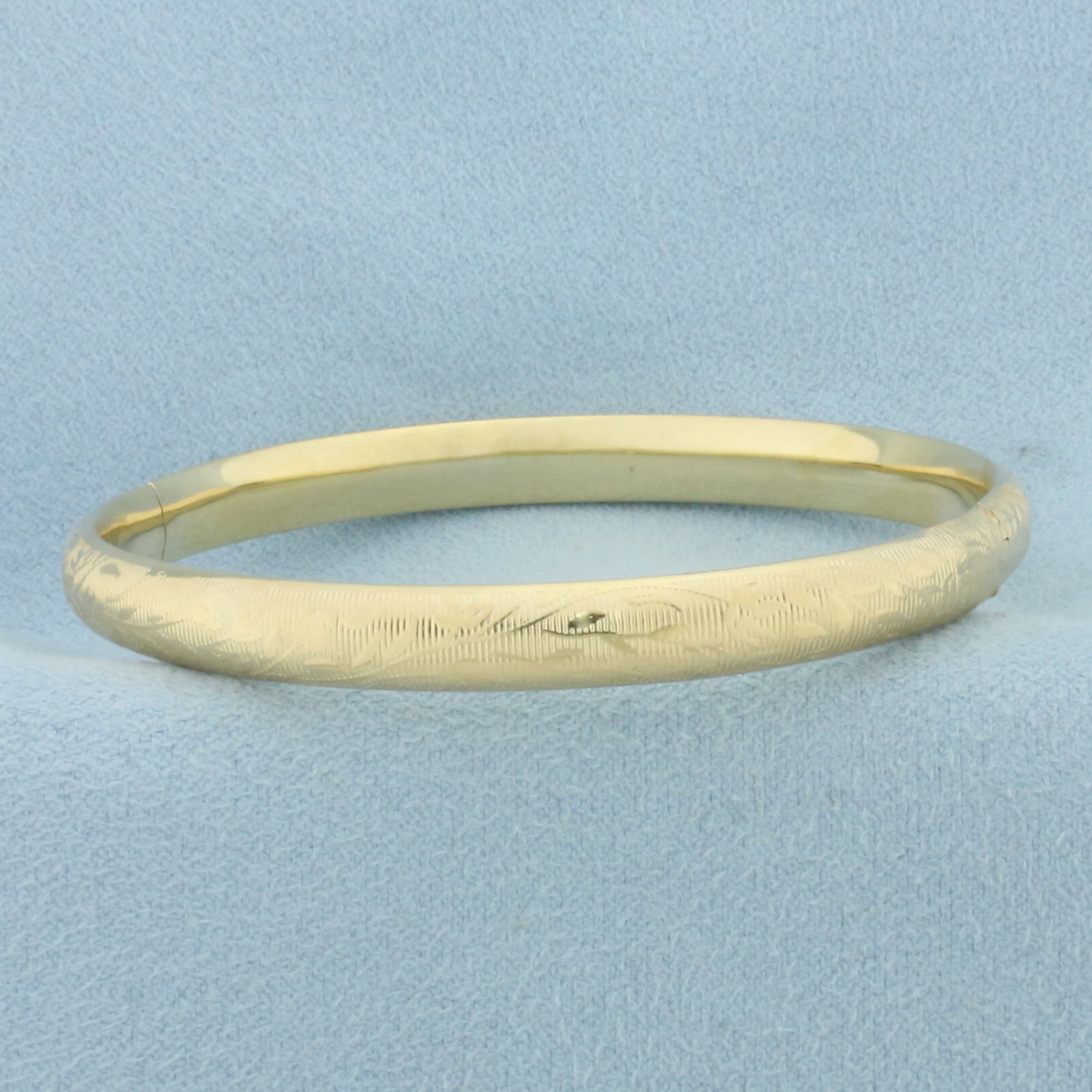 Floral Design Bangle Bracelet in 14k Yellow Gold: In 14k Yellow Gold. Interior dimensions: 2 1/4 inch by 2 1/8 inch. 6mm wide. Hinged closure. 8.1g.