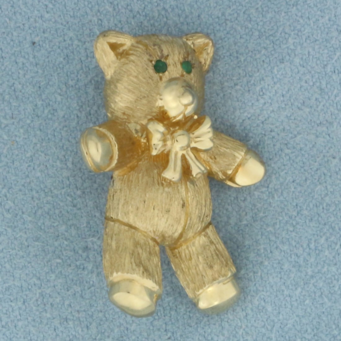 Teddy Bear Brooch Pin in 14K Yellow Gold: In 14k yellow gold. Contains 2 high quality natural 1mm Emerald gemstones as eyes. Measures 1 inch long by 3/4 inch wide. 6.9g.