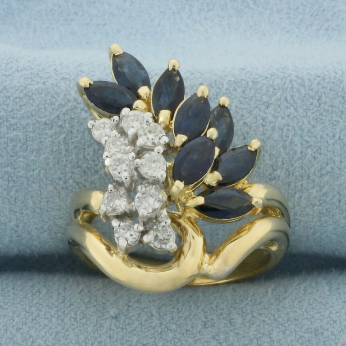 Vintage Sapphire and Diamond Ring in 14k Yellow Gold: In 14k yellow gold. 25mm wide at top of ring. Contains 8 high quality natural marquise cut Sapphires, 6x3mm each, with intense color and excellent clarity. Accented with ten high quality .05ct diamond