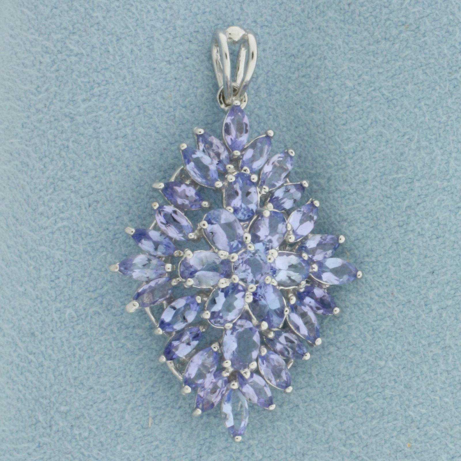 Tanzanite Pendant in 10k White Gold: In 10k White Gold. Contains one 3mm round cut, eight 4x3mm oval cut, and twenty-four 4x2mm marquise cut high quality natural Tanzanite gemstones, approximately 4ct TW, with bright color and excellent 