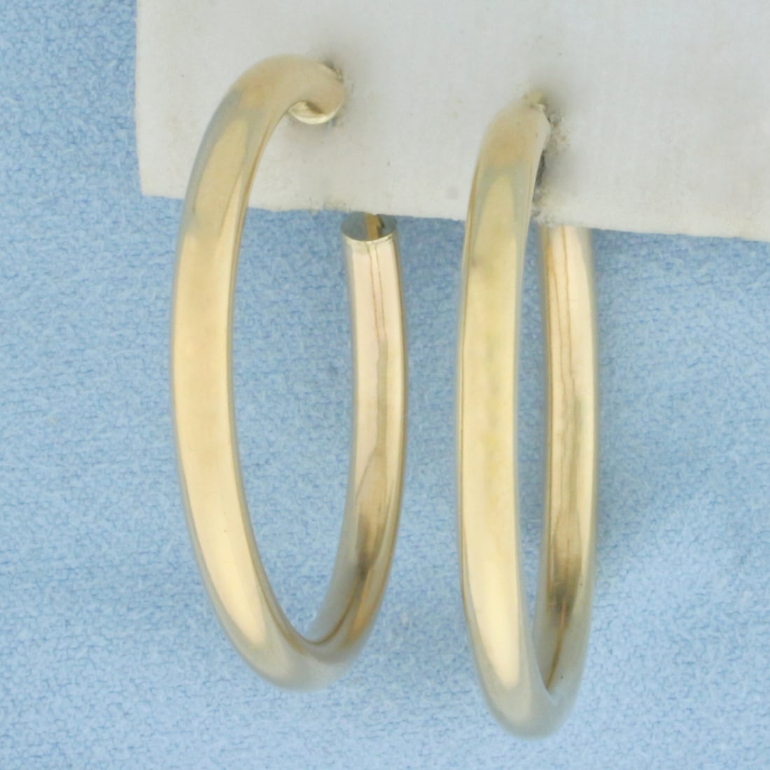 Hoop Earrings in 14k Yellow Gold: In 14k Yellow Gold. 1 1/4 inch long. 1 1/4 inch wide. 2.8mm wide tubes. Leverbacks. 3.3g.