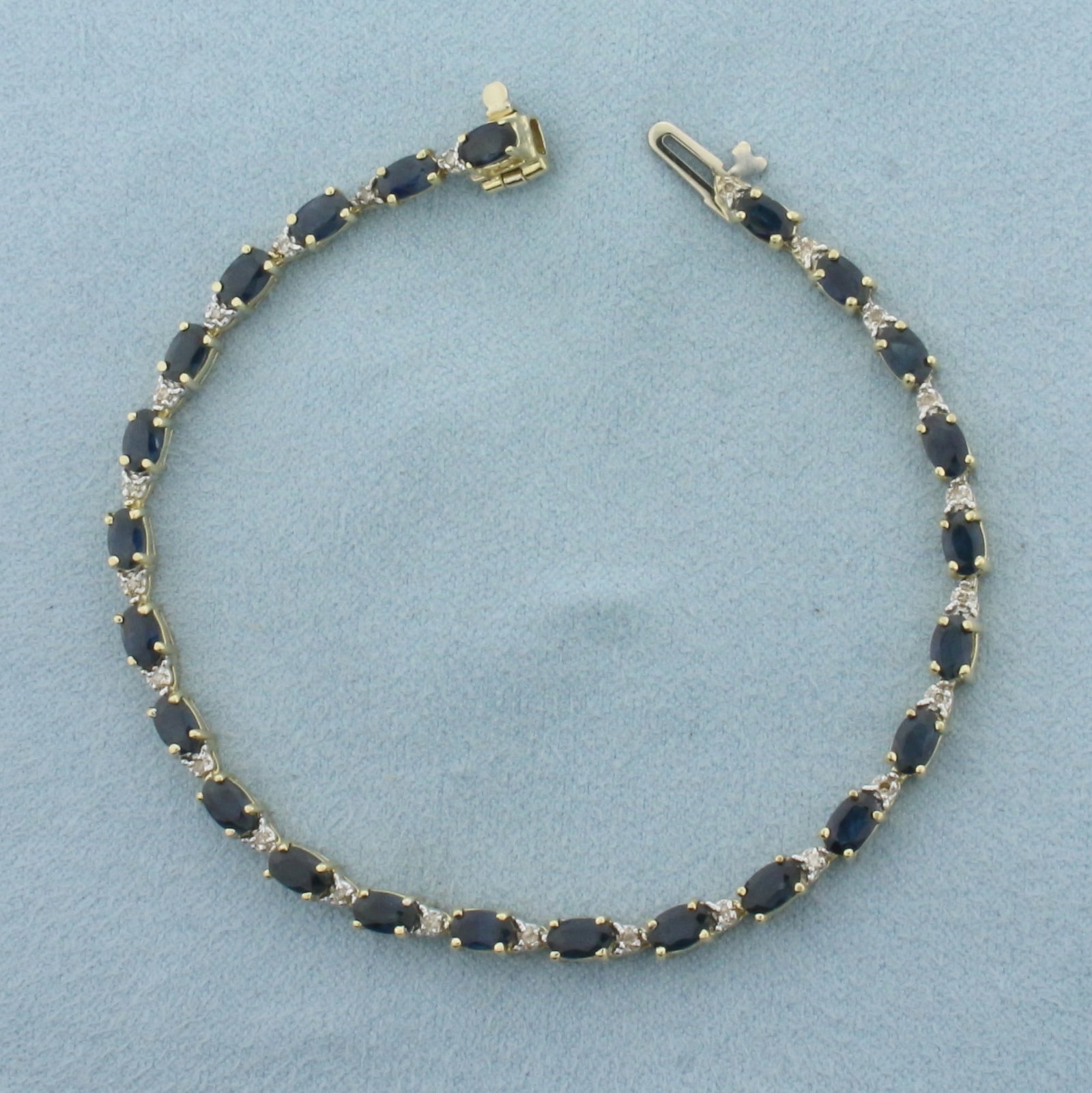 Sapphire and Diamond Tennis Bracelet in 14k Yellow Gold: In 14K Yellow Gold. 7 1/4 inches long. 3.5mm wide. Contains 24 high quality natural 5mm Sapphire gemstones, 6ct TW, with deep midnight blue color and excellent clarity. Also contains 24 high quality 1
