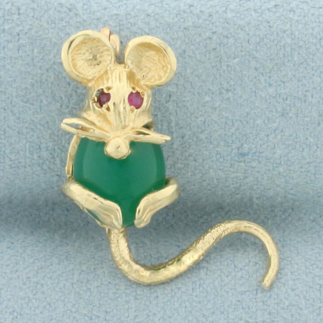 Emerald and Ruby Mouse Pin in 14k Yellow Gold: In 14k yellow gold. Contains one high quality 10m by 8mm Emerald gemstone with vibrant color. Also contains 2 high quality natural 1.5mm Ruby gemstones with intense color. 1 inch long, 3/4 inch wide. 