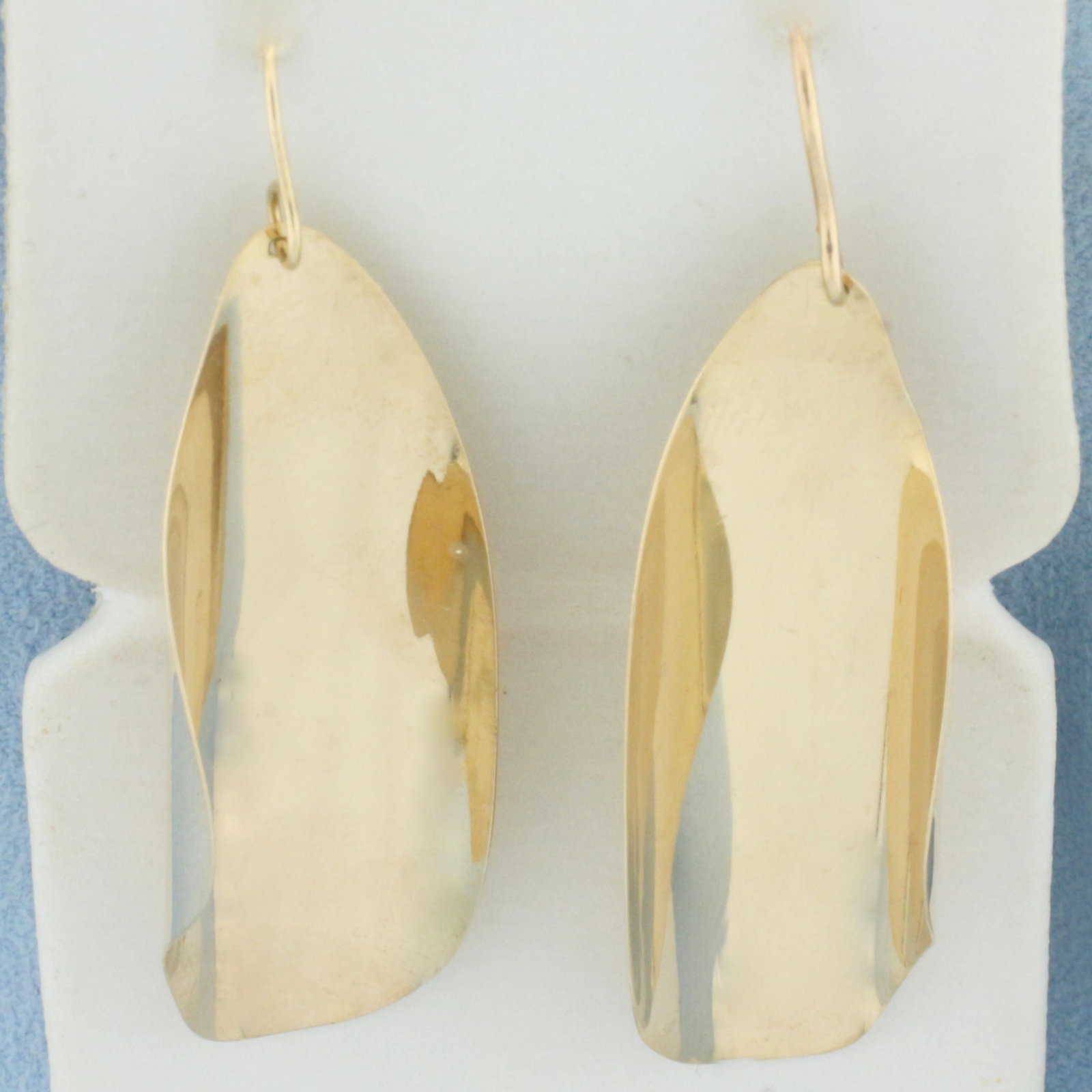 Curved Freeform Dangle Earrings in 14k Yellow Gold: In 14k Yellow Gold. Two 1/8 inch long by 1/2 inch wide earrings. Hook backs. 3.5g.
