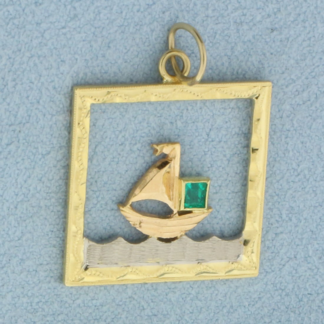 Emerald Sailing Boat Pendant in 14k Yellow Gold: In 14k Yellow Gold with White Gold Accents. Contains one high quality natural 4mm Emerald gemstone with vibrant color. 3/4 inch long. 3/4 inch wide. 3.2g.