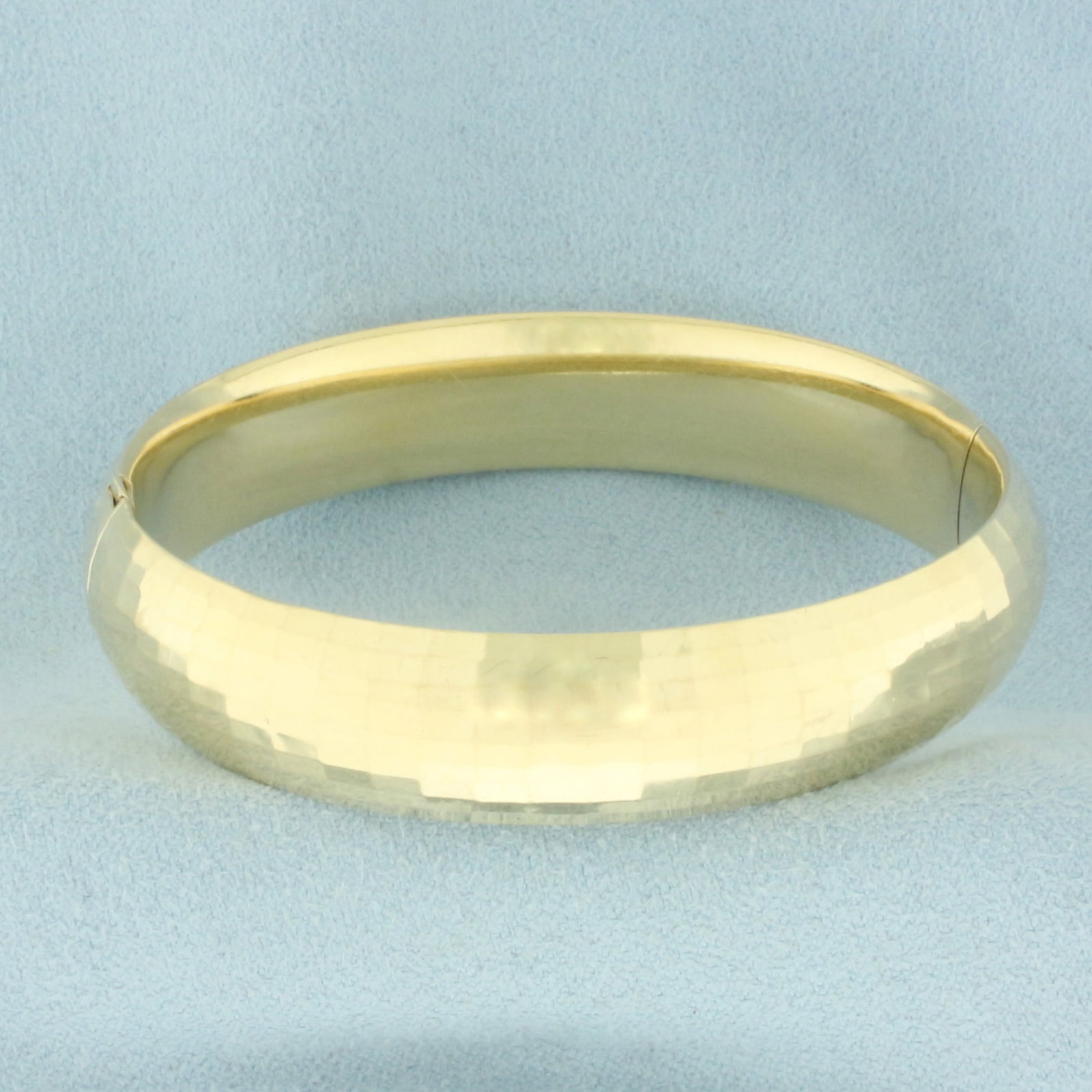 Disco Ball Finsh Hinged Bangle Bracelet in 14k Yellow Gold: In 14k Yellow Gold. Interior dimensions: 2 3/8 inch by 2 1/4 inch. 1/2 inch wide. Minor indentations, difficult to see when wearing. Disco ball like finish for added brilliance. Hinged opening, lockin