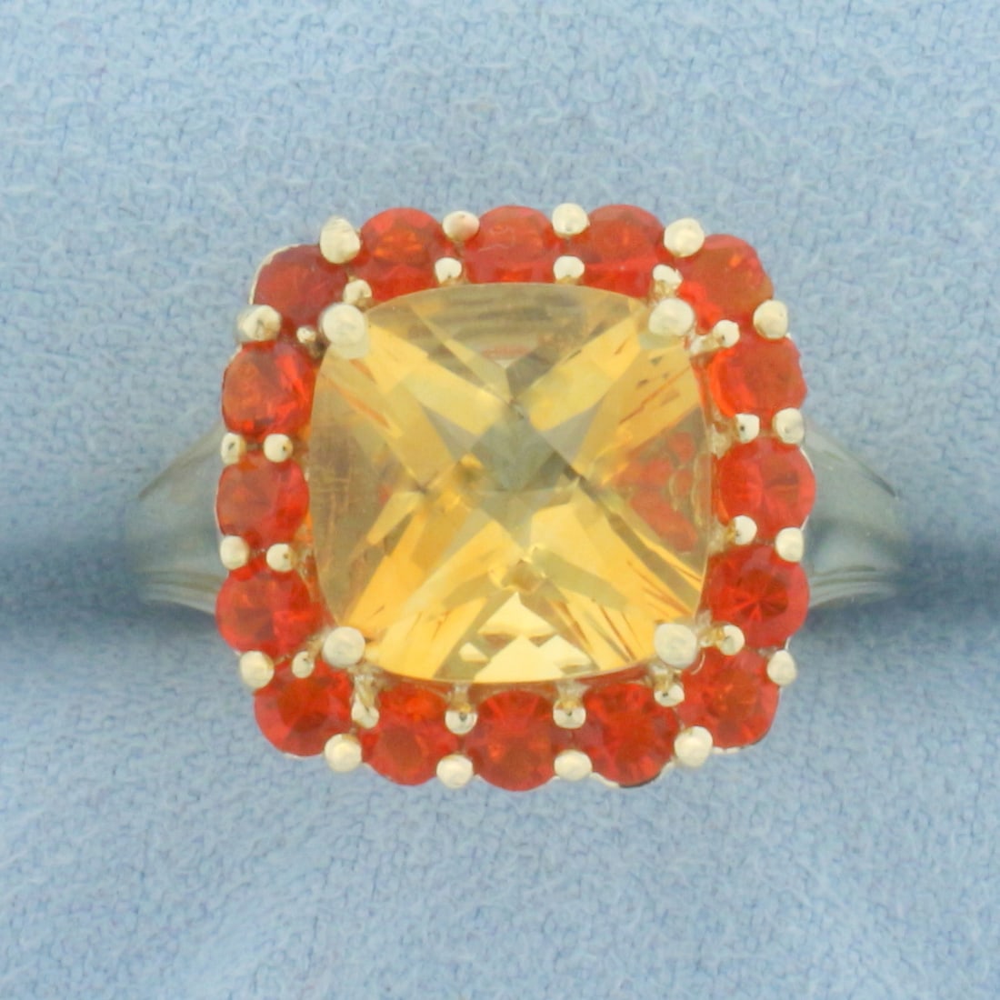 Citrine and Spessartite Garnet Halo Ring in 10k Yellow Gold: In 10k Yellow Gold. Contains one 10mm high quality checkerboard cut natural Citrine gemstone with bright color and excellent clarity. Also contains sixteen 3mm high quality natural Spessartite Garnet 