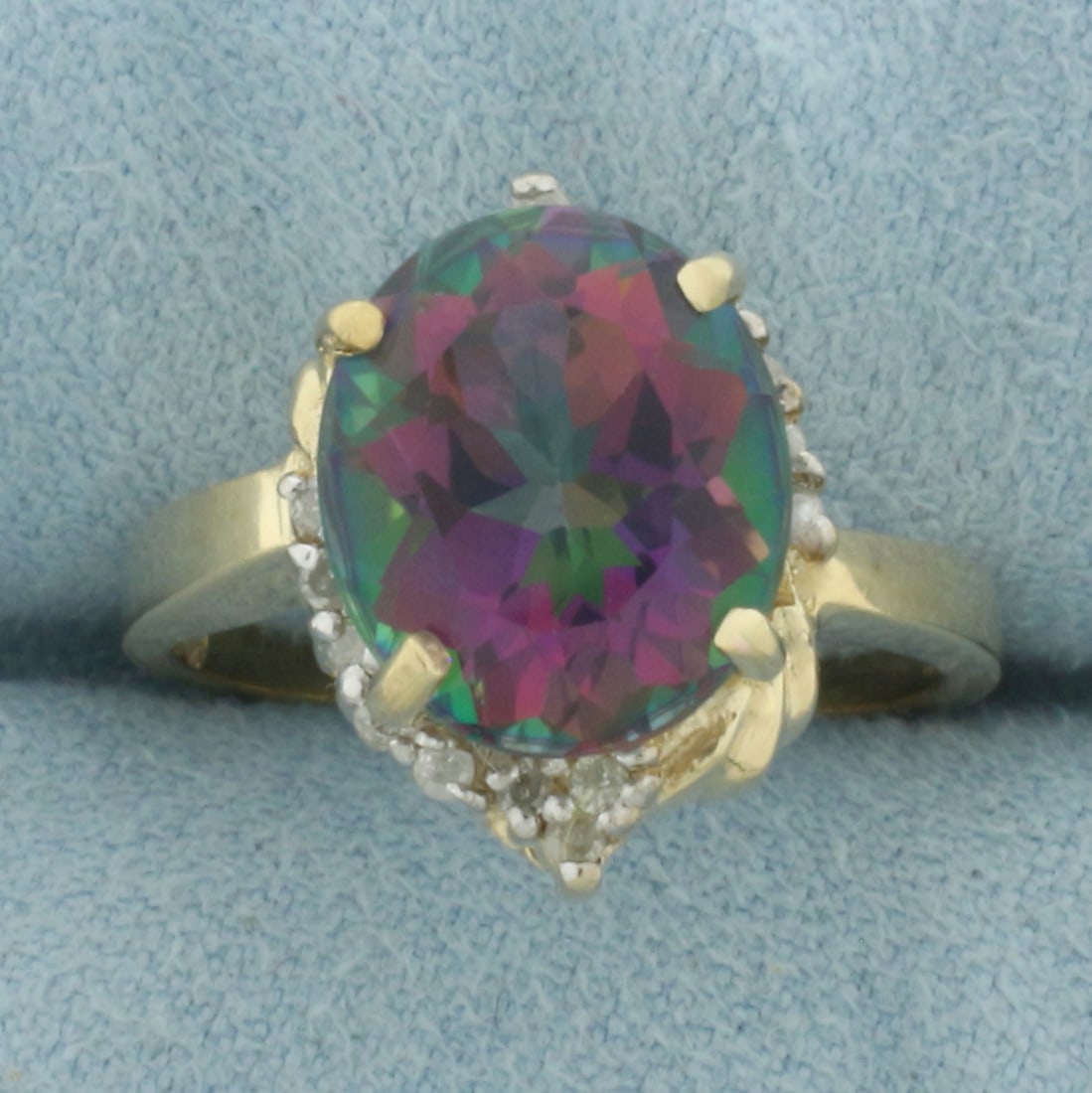 Mystic Topaz and Diamond Ring in 10k Yellow Gold: In 10k Yellow Gold. Contains one 12x10mm high quality oval cut Mystic Topaz gemstone, approximately 6cts, with vibrant color and excellent clarity. Also contains sixteen high quality 1/2pt diamonds. S