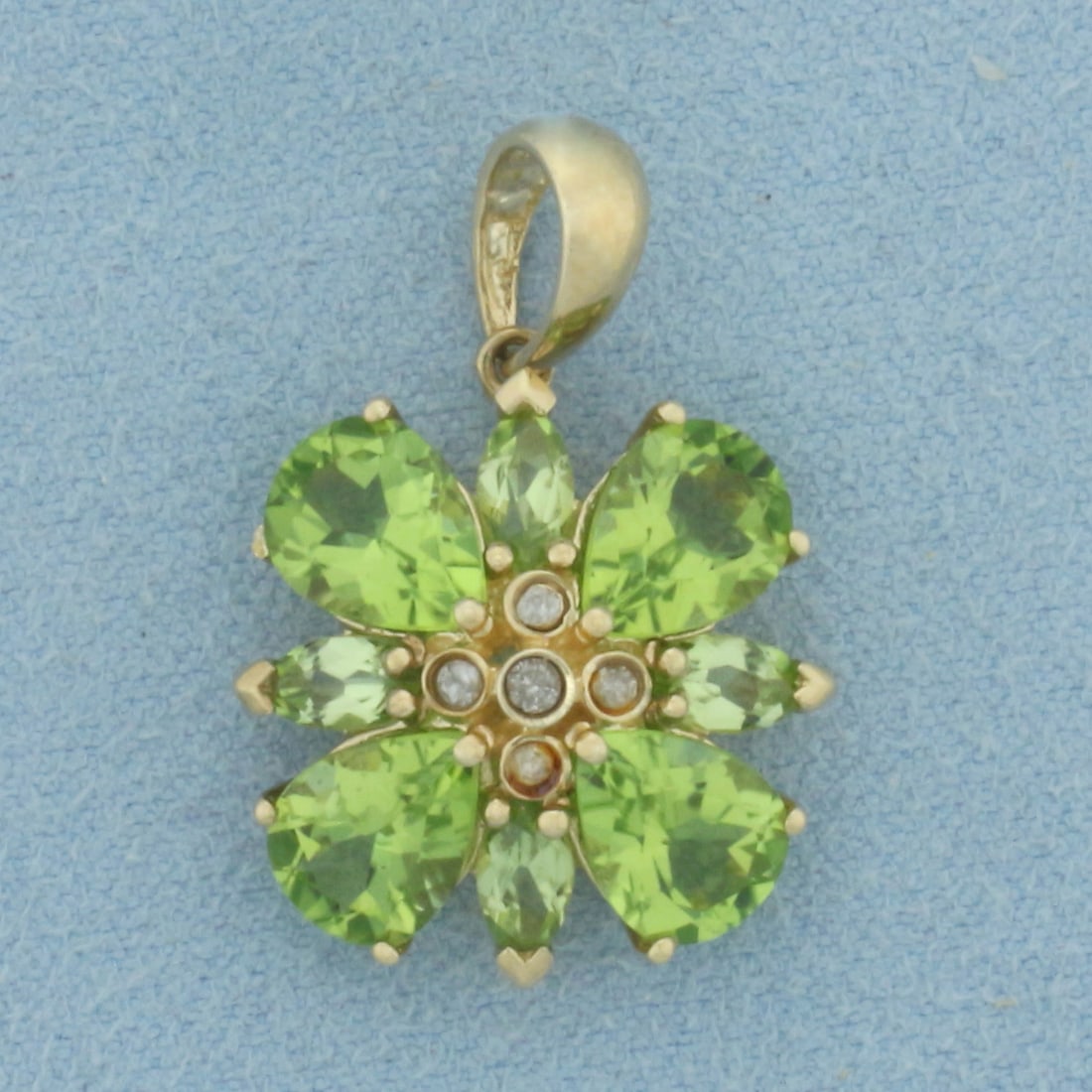 Peridot and Diamond Flower Pendant in 10k Yellow Gold: In 10k Yellow Gold. Contains four 8x6mm pear and four 6x3mm marquise cut high quality natural Peridot gemstones with bright color and excellent clarity. Also contains five .02ct high quality diamonds.