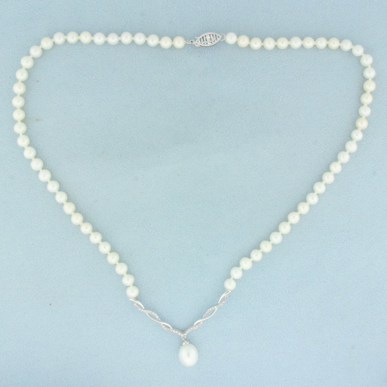 Vintage Cultured Pearl and Diamond V-Drop Necklace in 10k White Gold: In 10k white gold. Contains one high quality 10mm center cultured pearl and sixty-six high quality 5mm cultured pearls with high luster. Hand knotted strand. Also contains 39 high quality 1/2pt