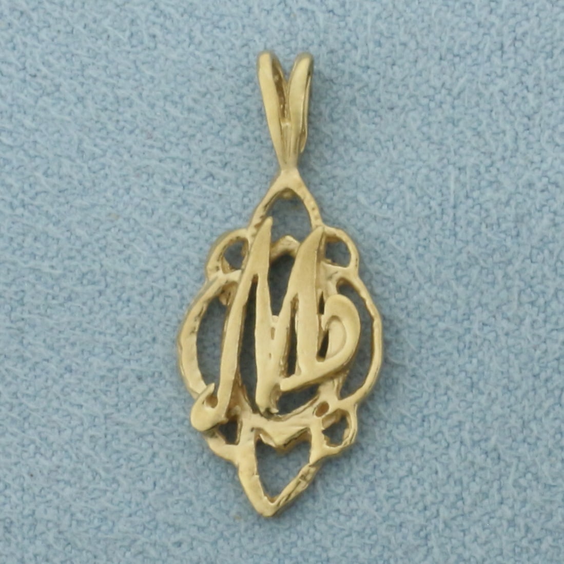 M Initial Pendant in 14k Yellow Gold: In 14k Yellow Gold. 1 inch long (including bale). 3/8 inch wide. 1.2g.