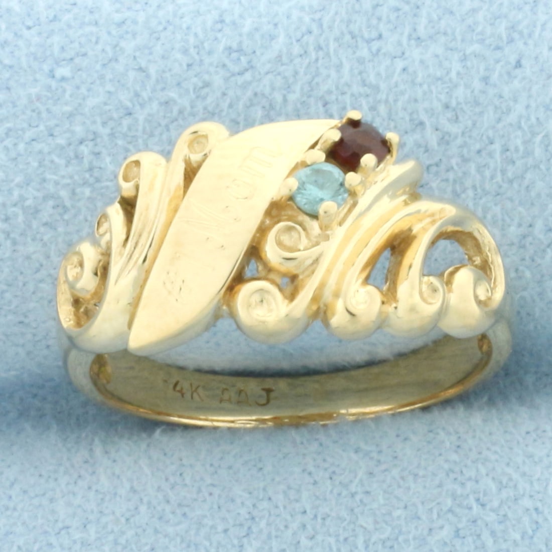 Number One Mom Gemstone Ring in 14k Yellow Gold: In 14k yellow gold. Contains one garnet and one blue topaz 2.5mm high quality natural gemstones with intense color and excellent clarity. 10.4mm wide at center. Size: 8. 4.2g.