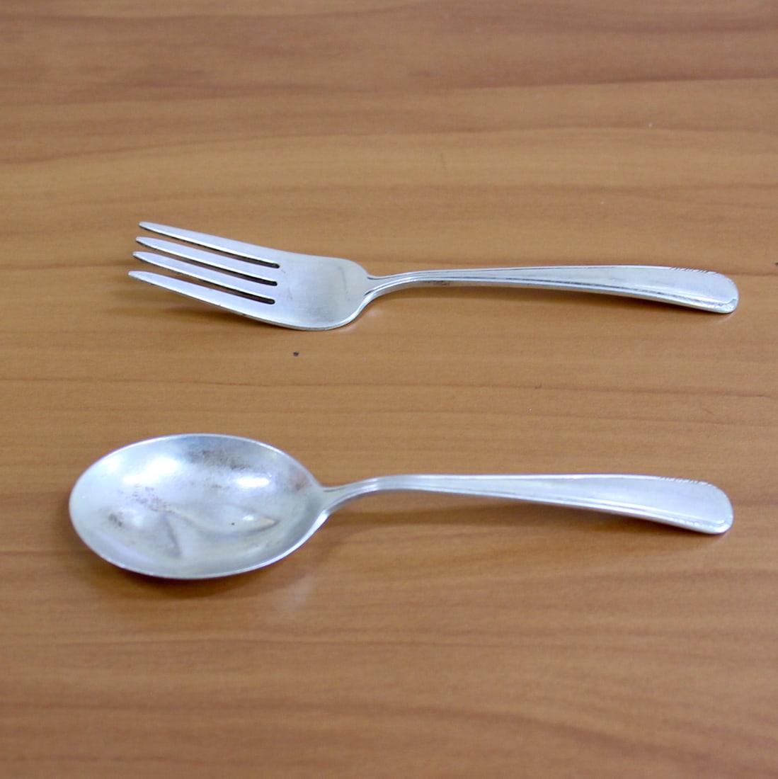 Manchester "Silver Stream" Sterling Silver Baby Spoon and Fork Set: In .925 Sterling Silver. Contains one baby fork, 4.75 inches long, and one baby spoon, 4 5/8 inches long. Slight dent in spoon bowl. 34.7g.
