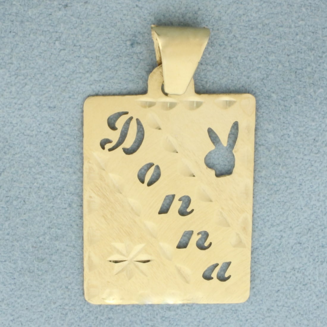 Donna Playboy Cutout Dog Tag Pendant in 14k Yellow Gold: In 14k Yellow Gold. 1 3/8 inch long (including bale). 3/4 inch wide. 2.0g.