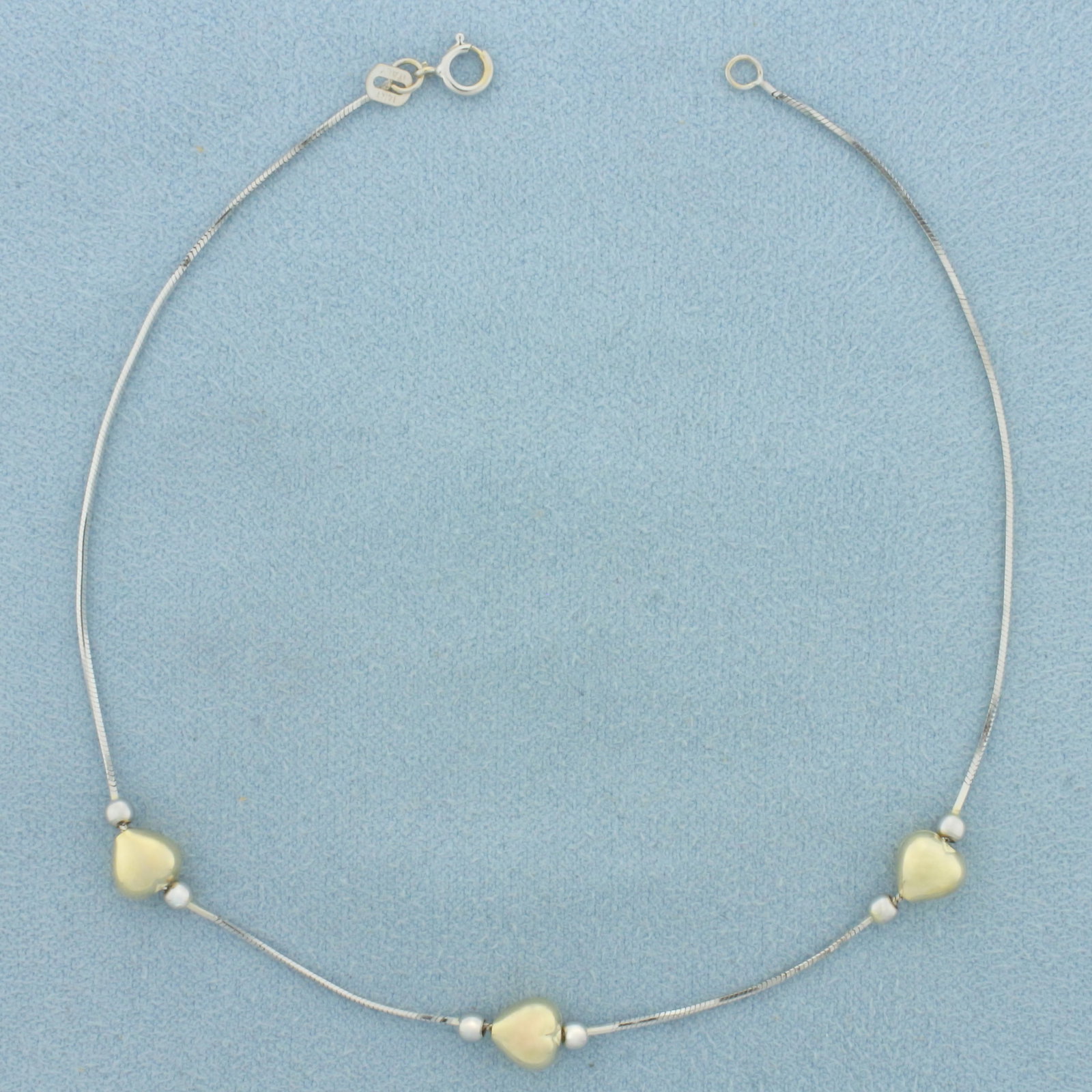 Heart and Ball Bead Anklet in 14k Yellow and White Gold: In 14k White and Yellow Gold. 9 inches long. 0.6mm wide. 6.1mm wide hearts. 2.5mm wide ball beads. Spring clasp. 2.0g.