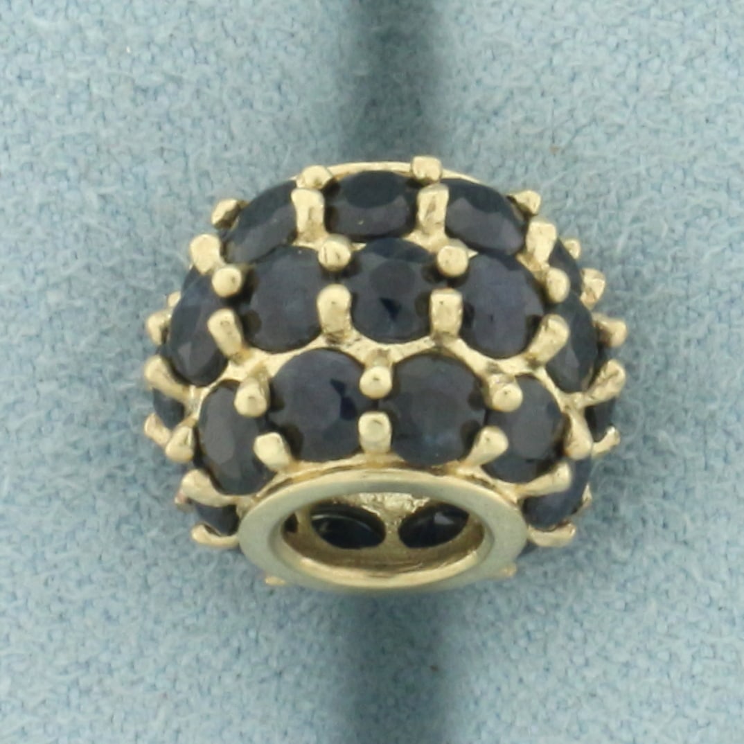 Sapphire Bead Charm in 10k Yellow Gold: In 10k yellow gold. Contains thirty-two high quality natural 3mm Sapphire gemstones with deep blue color. 3/8 inches x 1/2 inches. 2.8g.